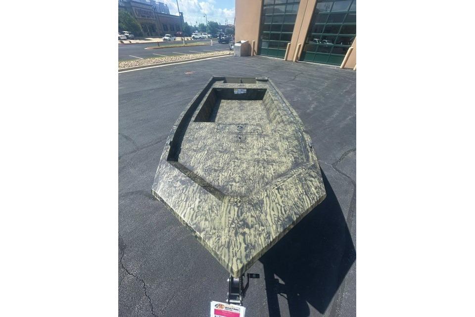 2026 Tracker Grizzly 1754 Utility boat with camouflage design on pavement.