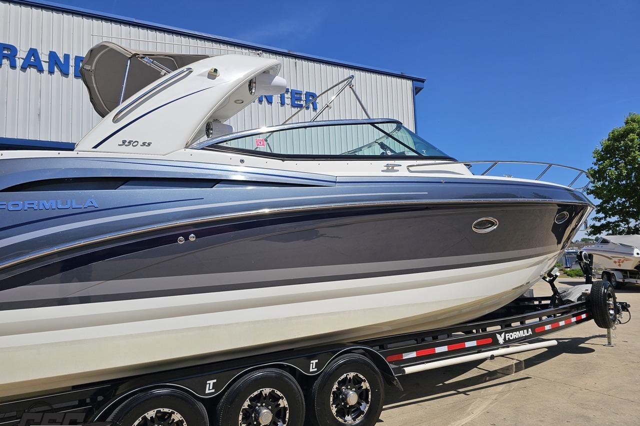2015 Formula 350 Sun Sport boat on trailer, parked outdoors under clear blue sky.