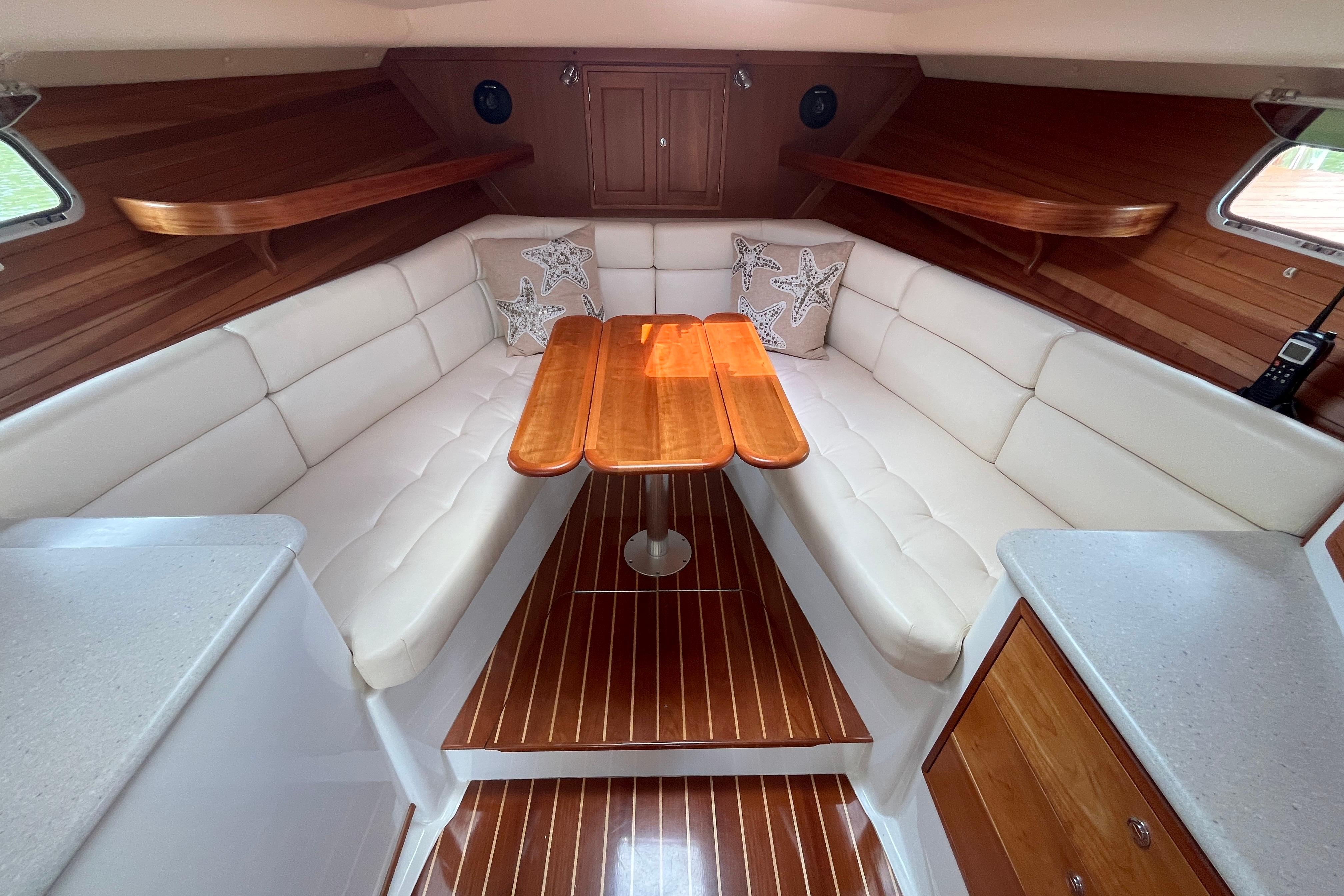 Luxurious 2006 MJM 34z yacht interior with elegant wood and white leather seating.