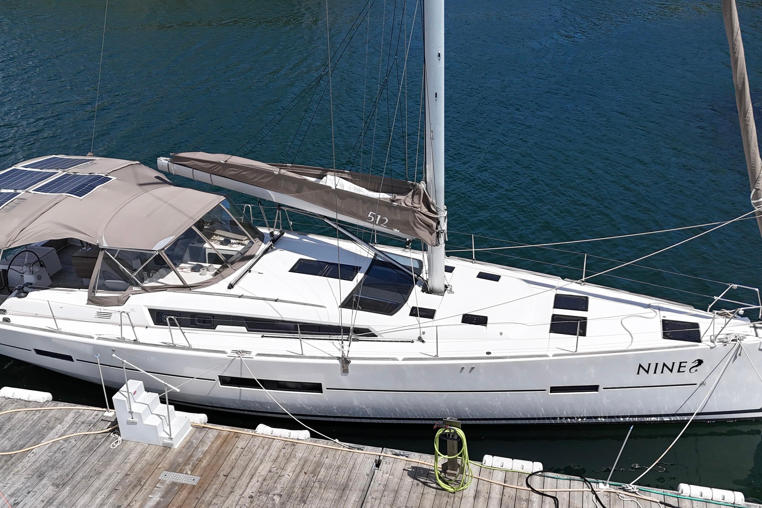 2016 Dufour 512 Grand Large sailboat docked in marina, featuring sleek design and solar panels.
