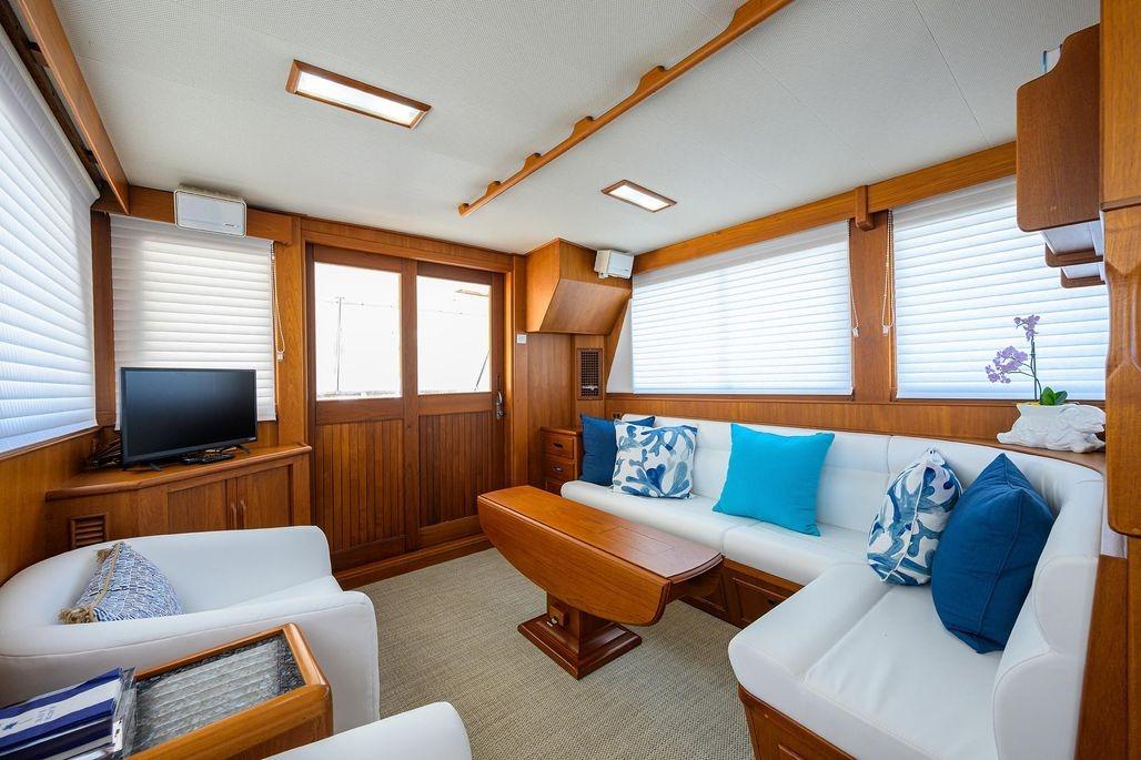 Luxurious interior of 1999 Grand Banks 42 Europa yacht with elegant wood finish and cozy seating.