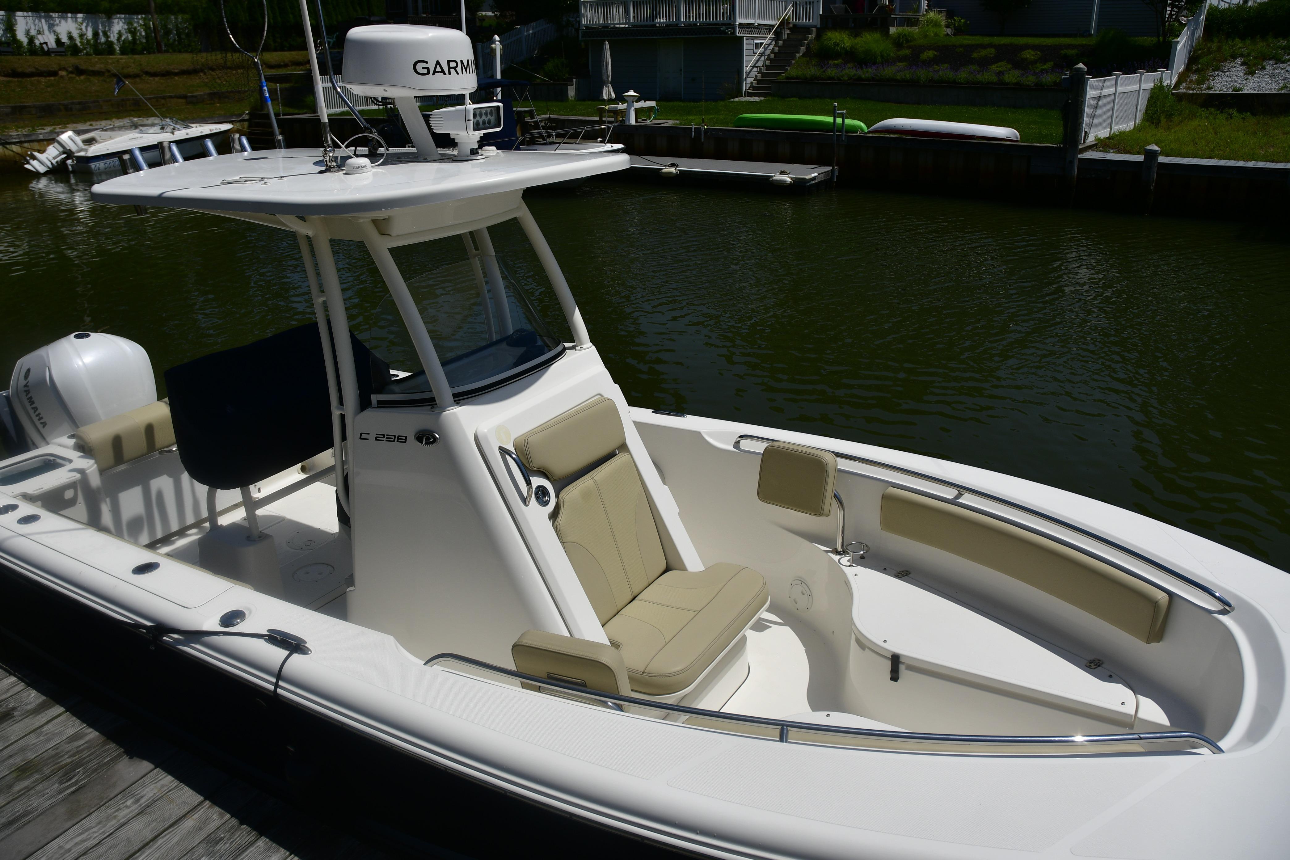 2020 Pursuit C 238 Center Console boat docked by a calm waterfront.