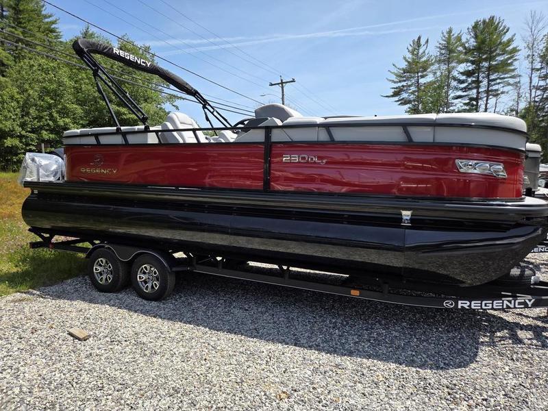 2025 Regency 230 DL3 pontoon boat on trailer, red and black design, parked outdoors.