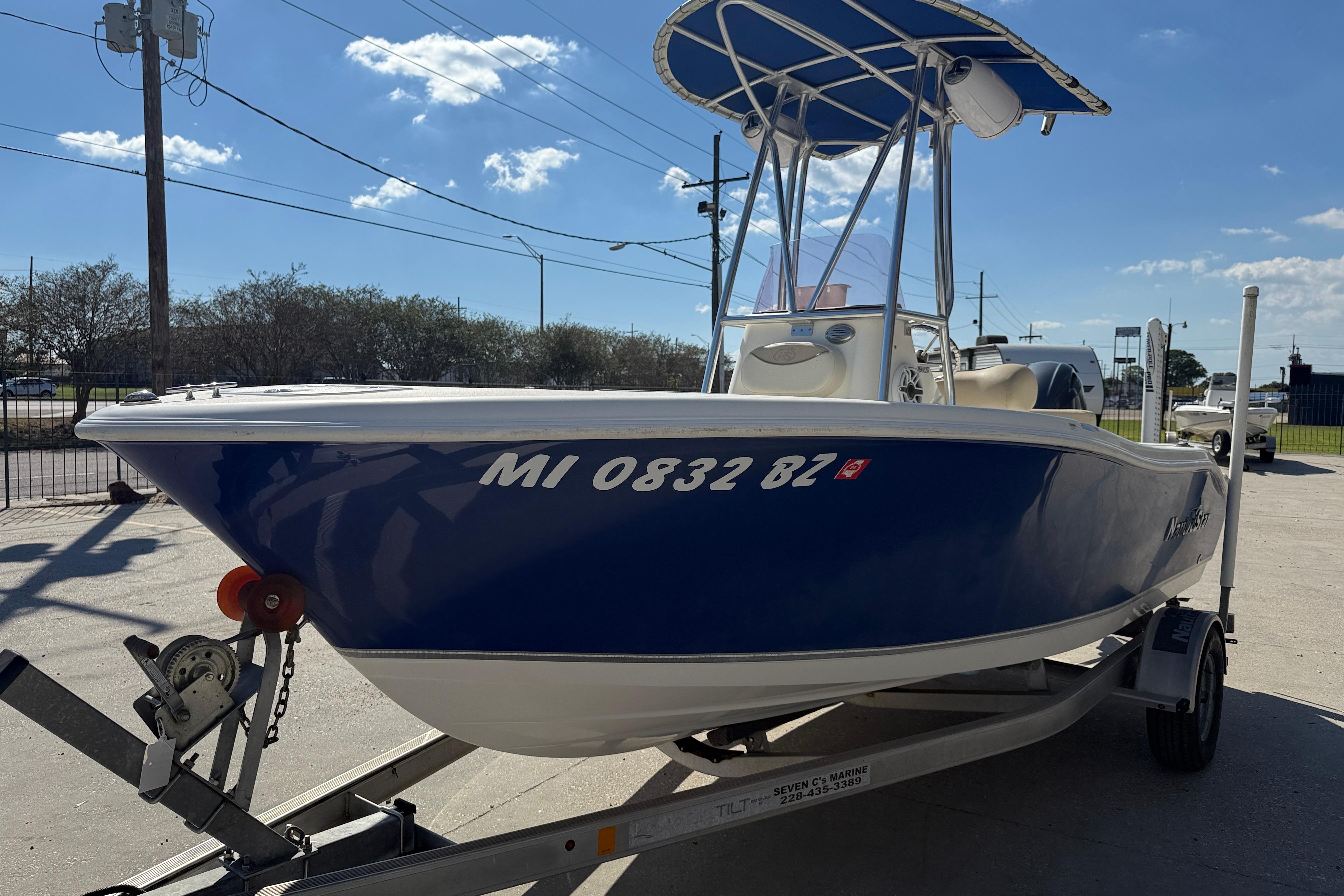 2019 NauticStar 19 XS boat on trailer, blue hull, sunny day.