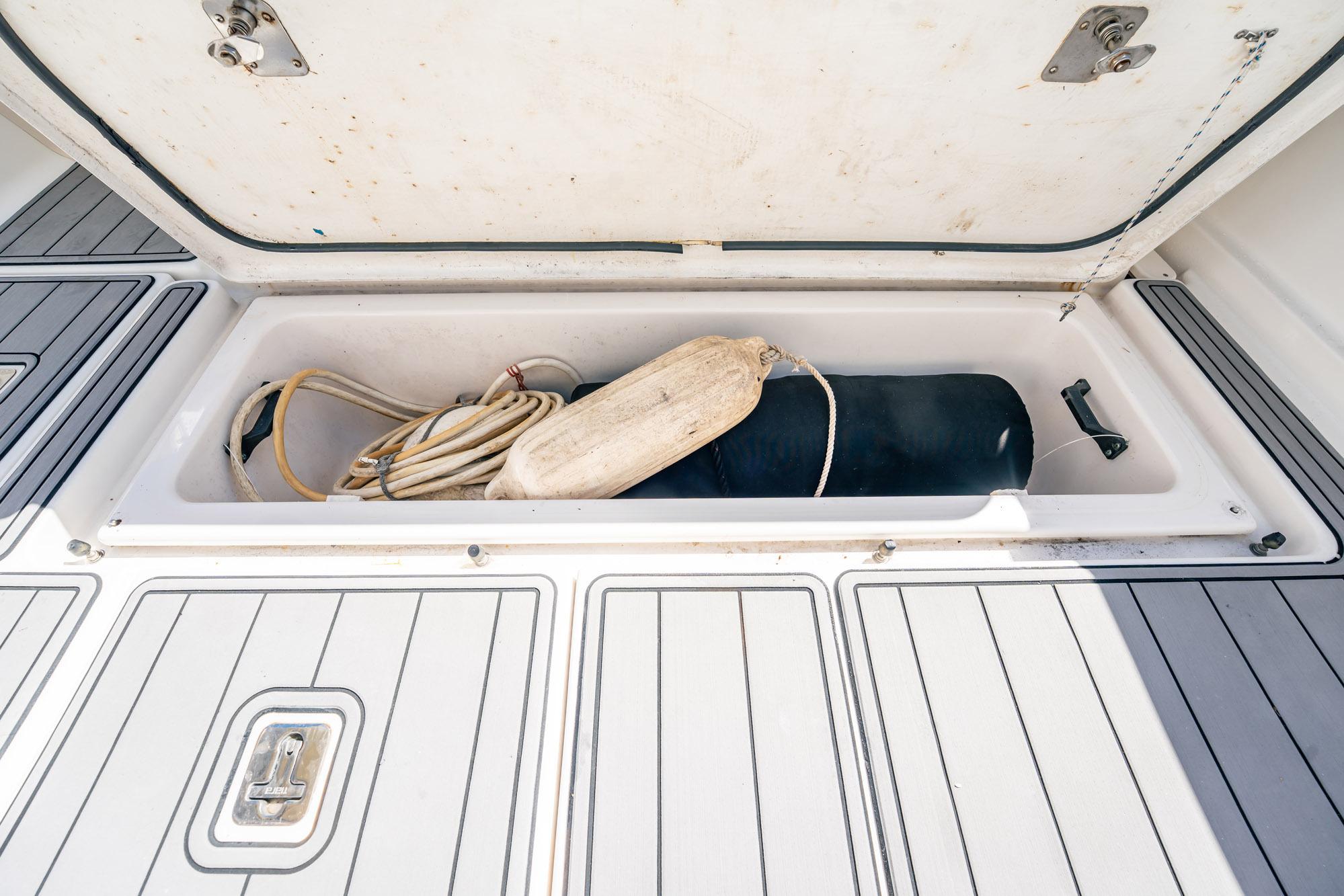 Open storage compartment on 2005 Tiara Yachts 3200 Open, containing rope and fender.