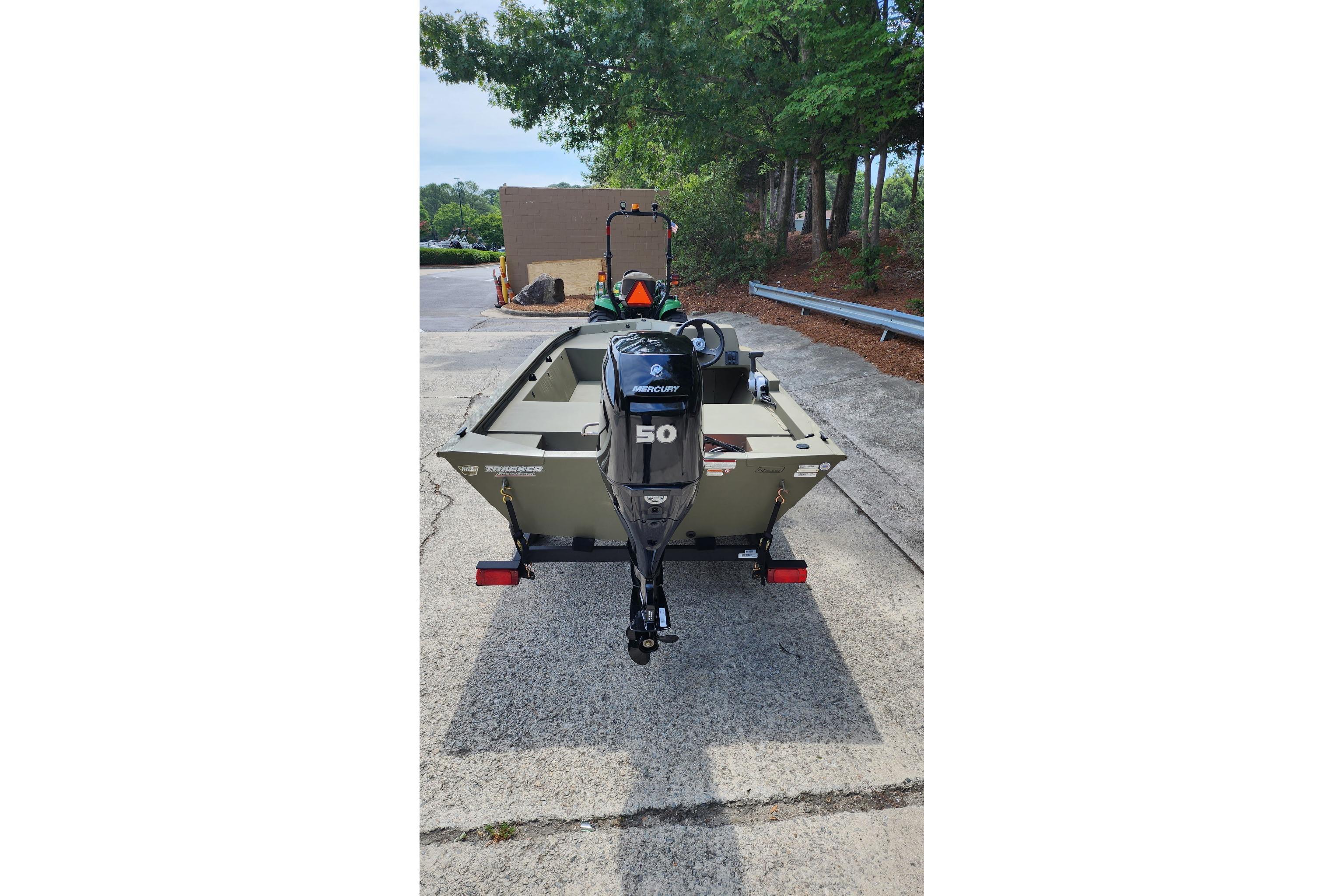 2026 Tracker Grizzly 1648 SC boat with Mercury 50 engine, parked outdoors.