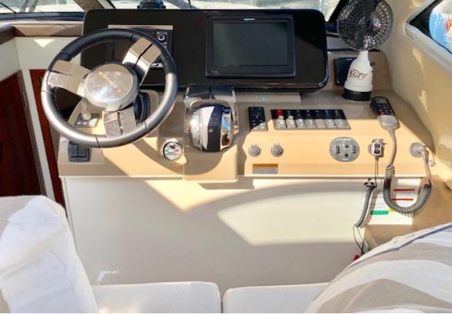 Helm of 2016 Carver C37 yacht with steering wheel, controls, and navigation display.