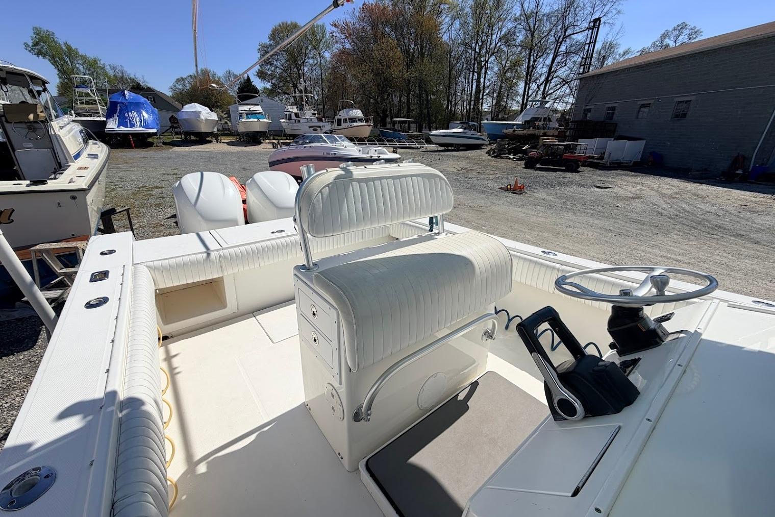 2006 Regulator 29 Forward Seating boat interior with steering wheel and seating, in a boatyard.