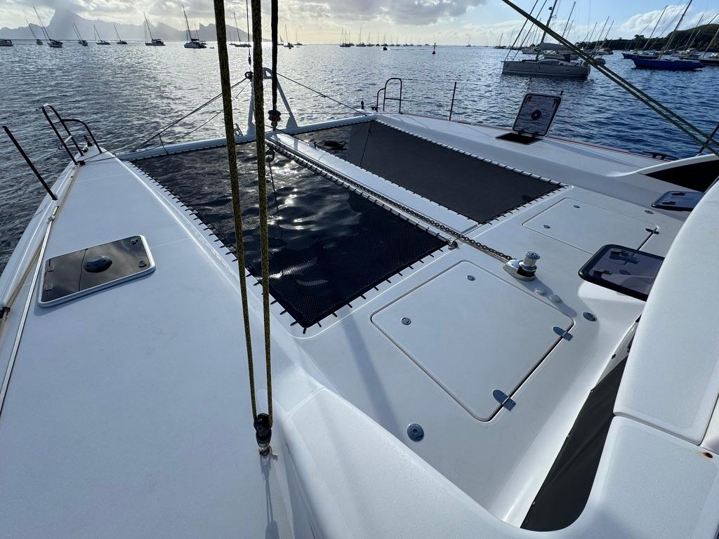 2022 Outremer 5X catamaran deck with ocean view and moored boats.