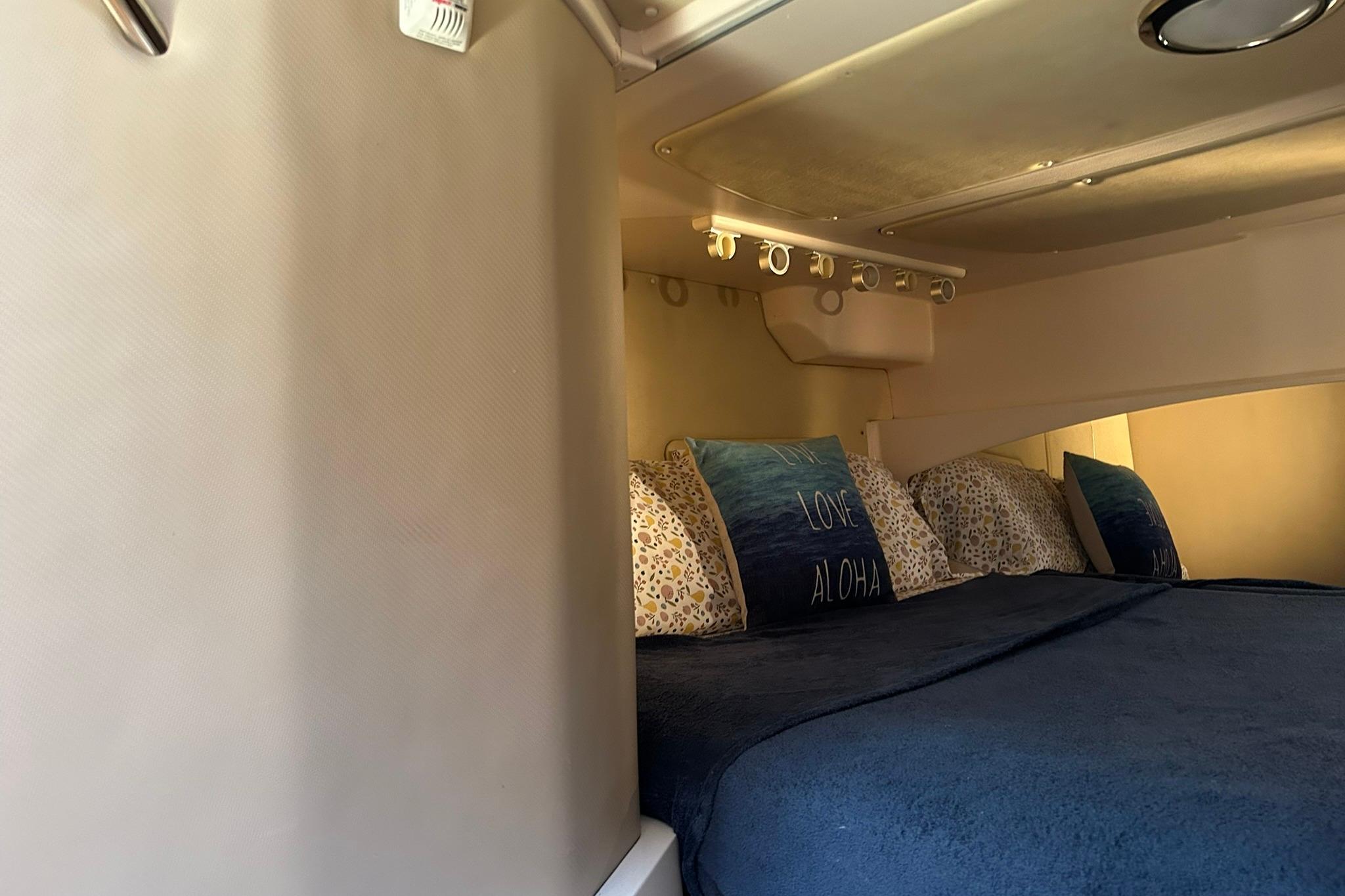Interior cabin of 2007 Grady-White Express 360 with cozy bedding and decorative pillows.