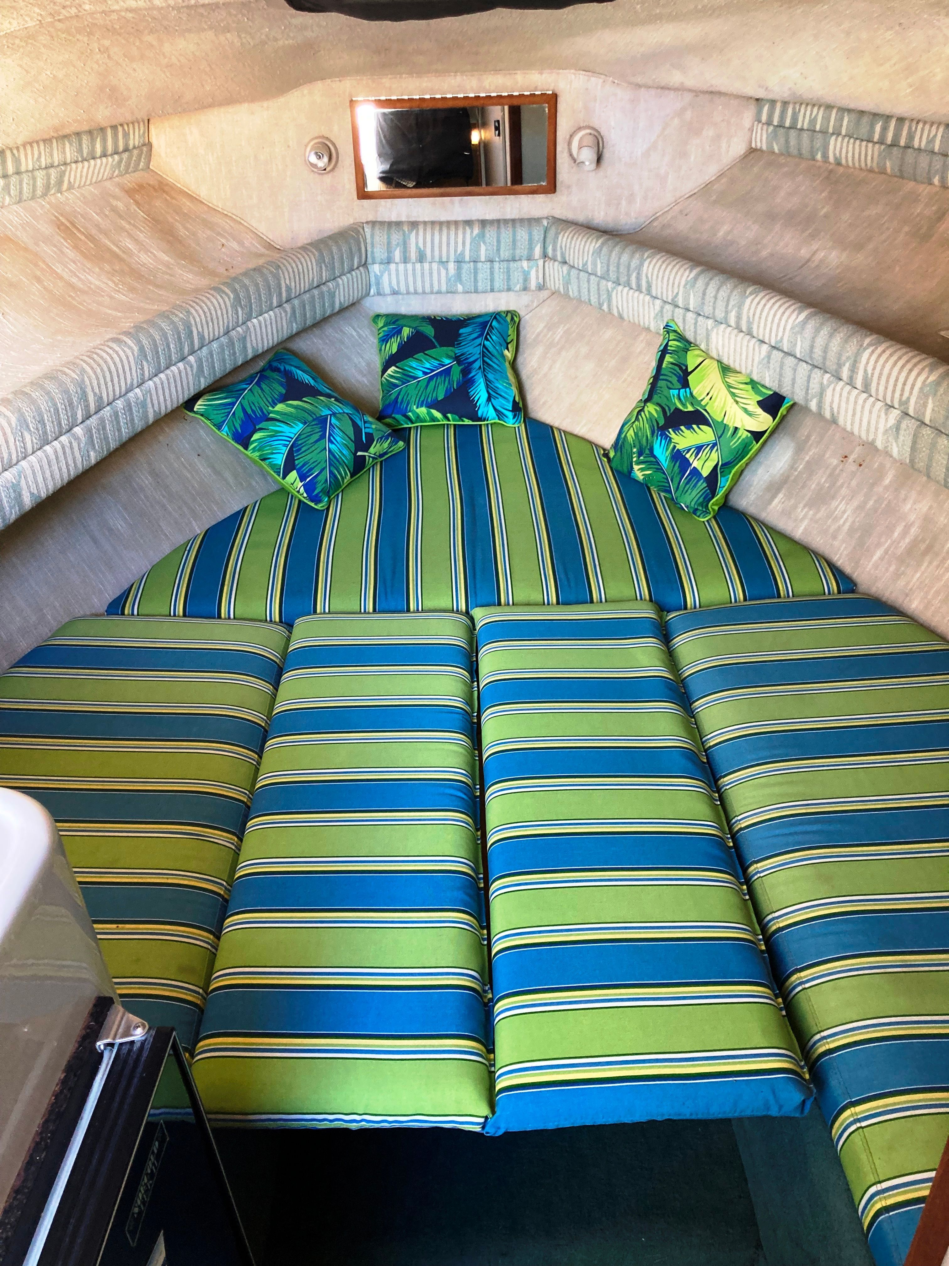 The image shows the interior of a 1991 Sea Ray 220 Sundancer with striped upholstery.
