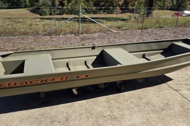 2026 Tracker Grizzly 14 Jon boat on concrete, outdoors, with grassy background.