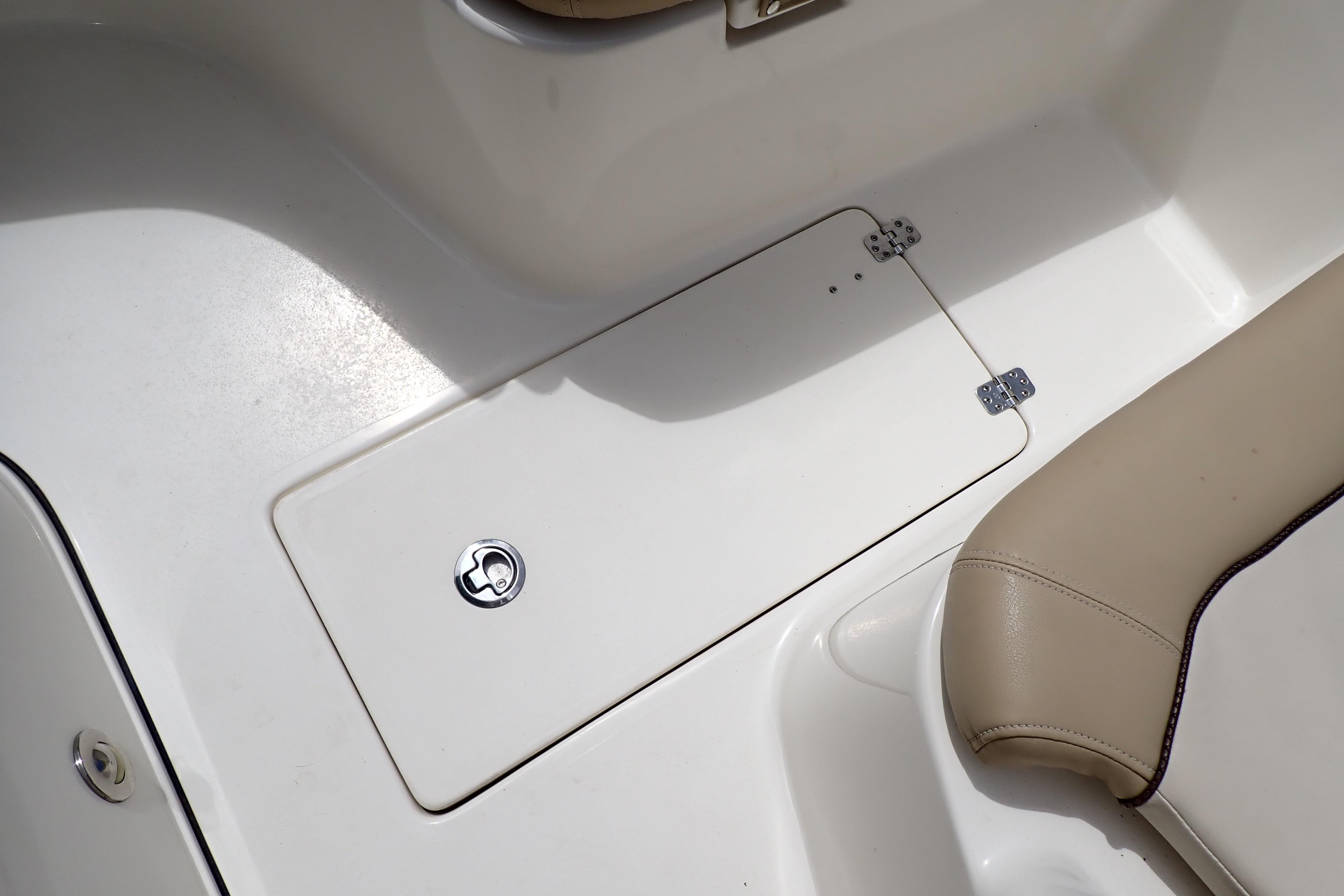 2019 Key West 263 FS boat interior with storage compartment and beige seating.