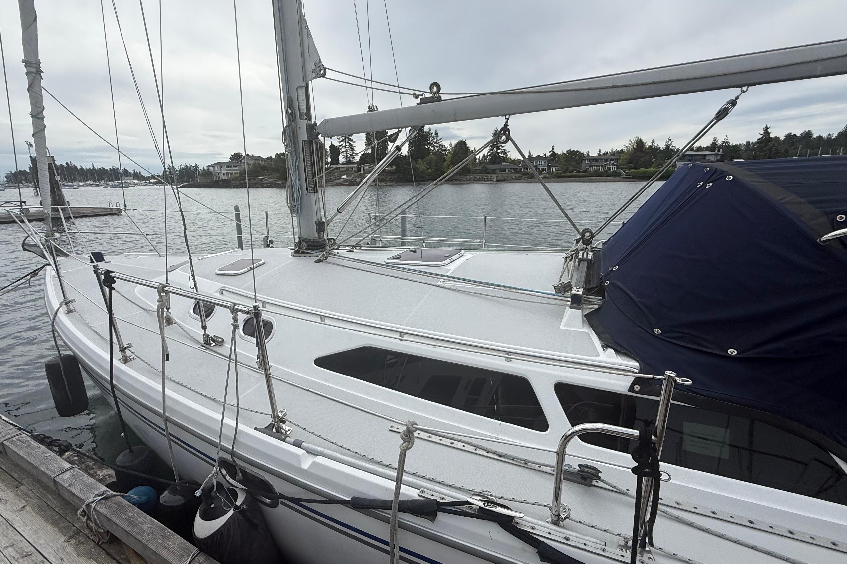 2005 Catalina 36 MkII sailboat docked by the waterfront on a cloudy day.