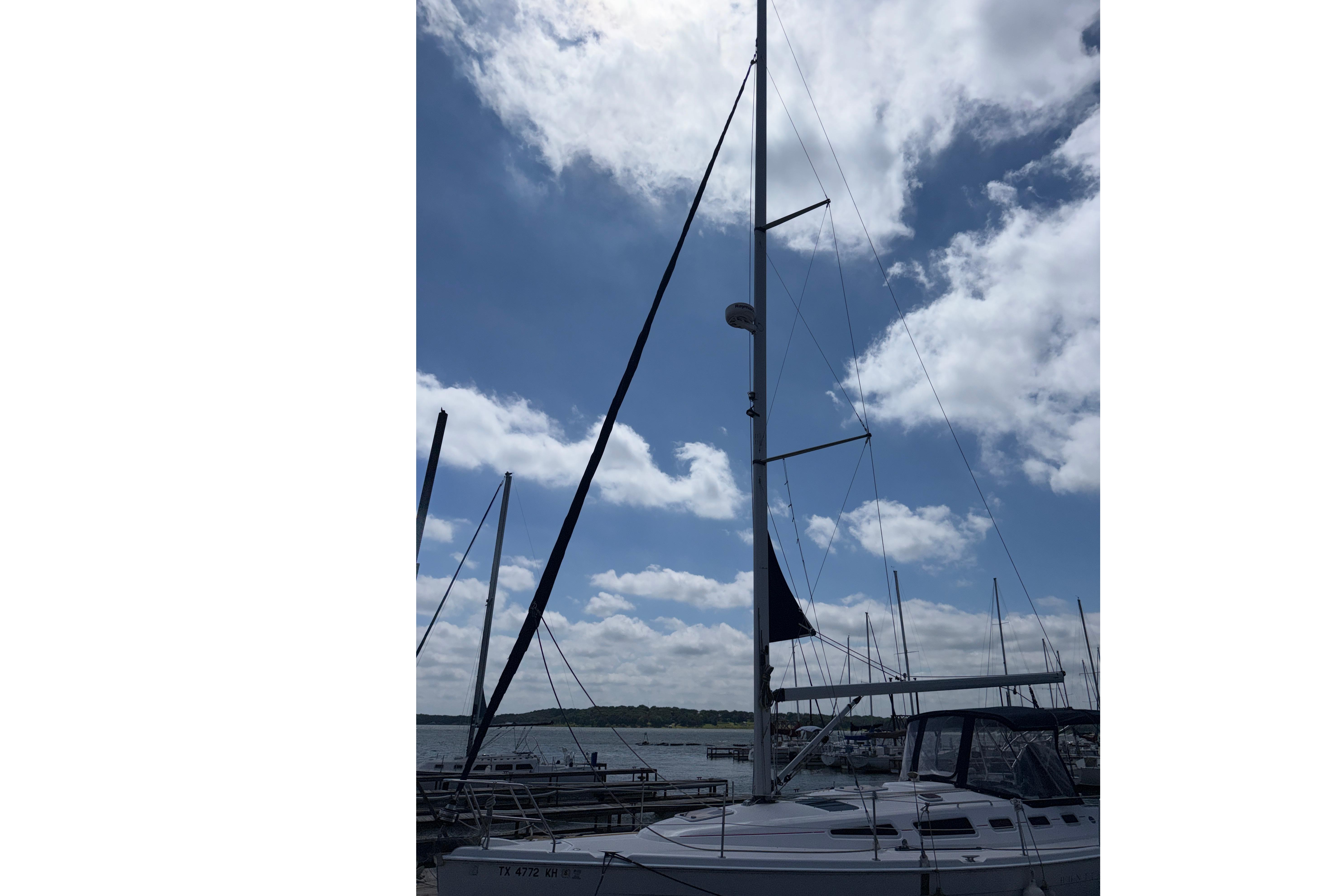 Sailboat Hunter 38, 2005 model, docked under a partly cloudy sky.