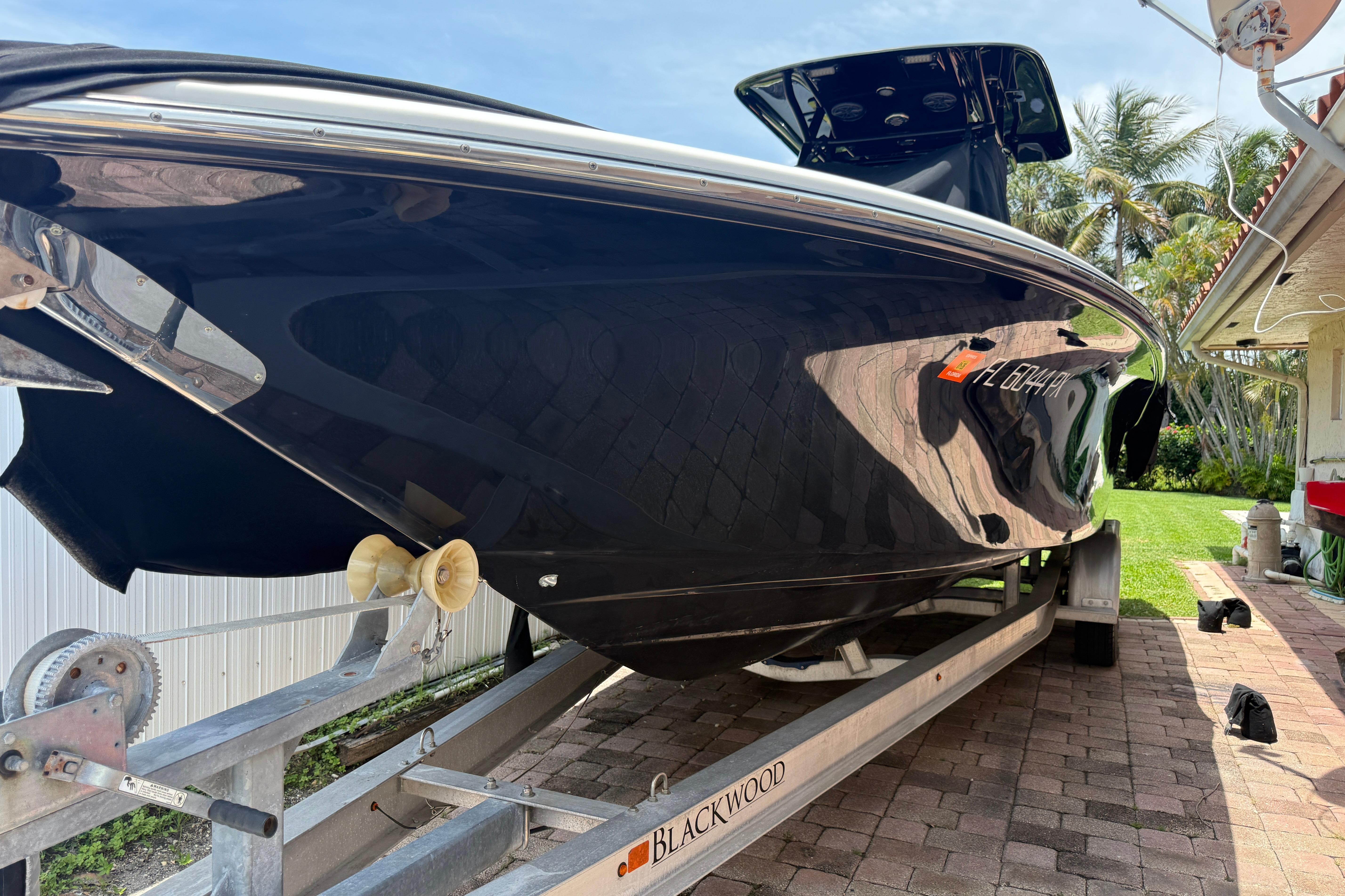 2015 Blackwood 27 boat on trailer, parked outdoors on a sunny day.