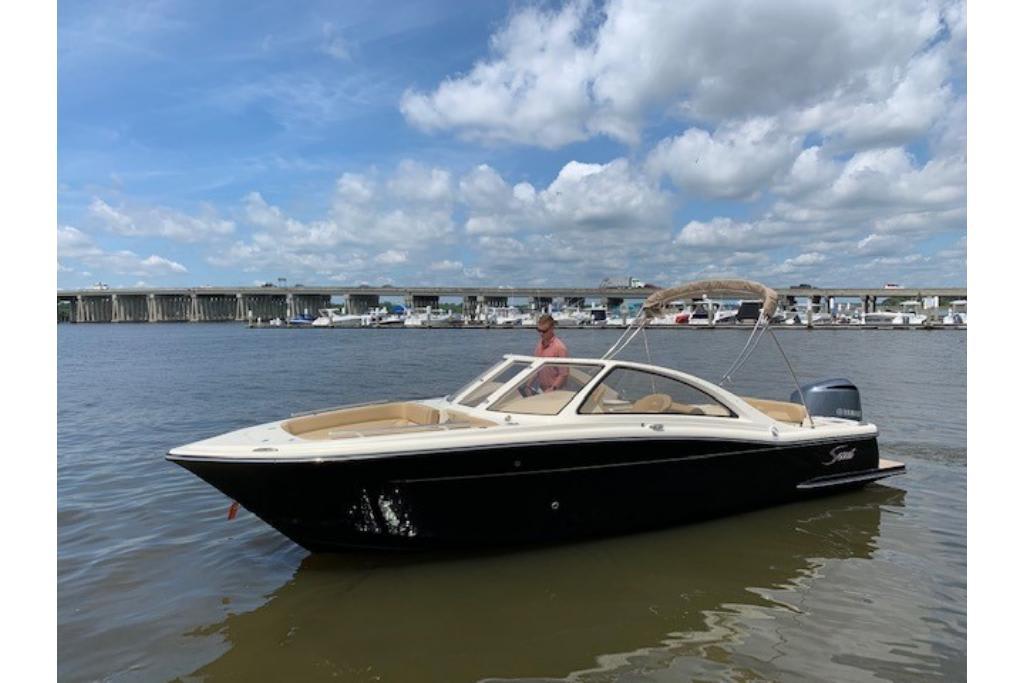 2023 Scout 240 Dorado boat on water with bridge and marina in background.