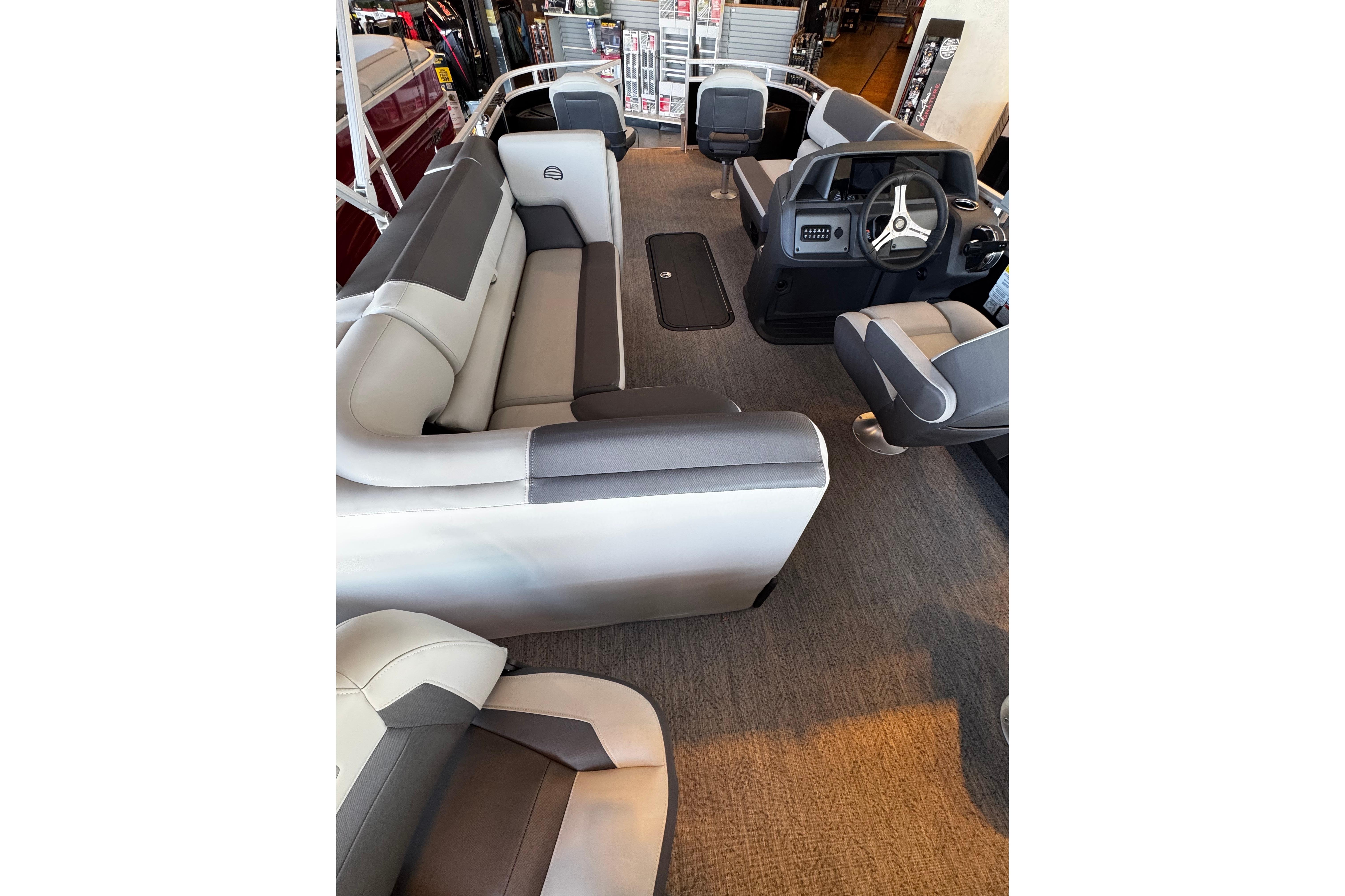 Interior view of 2026 Sun Tracker Fishin' Barge 22 XP3 pontoon boat with seating and helm.