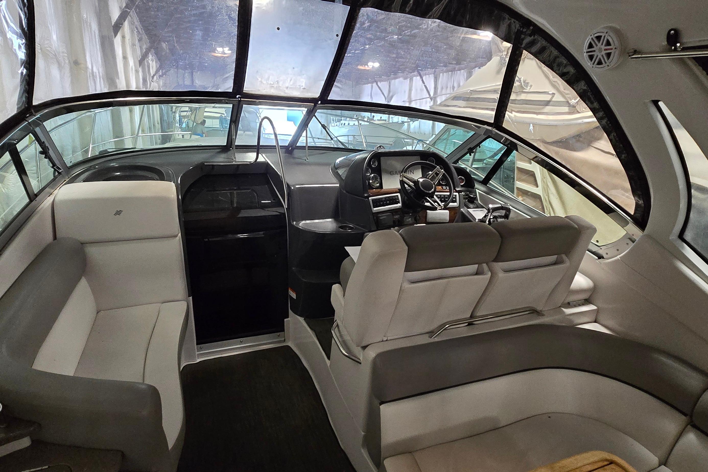 Interior of a 2018 Four Winns V355 boat, featuring a modern helm and seating area.