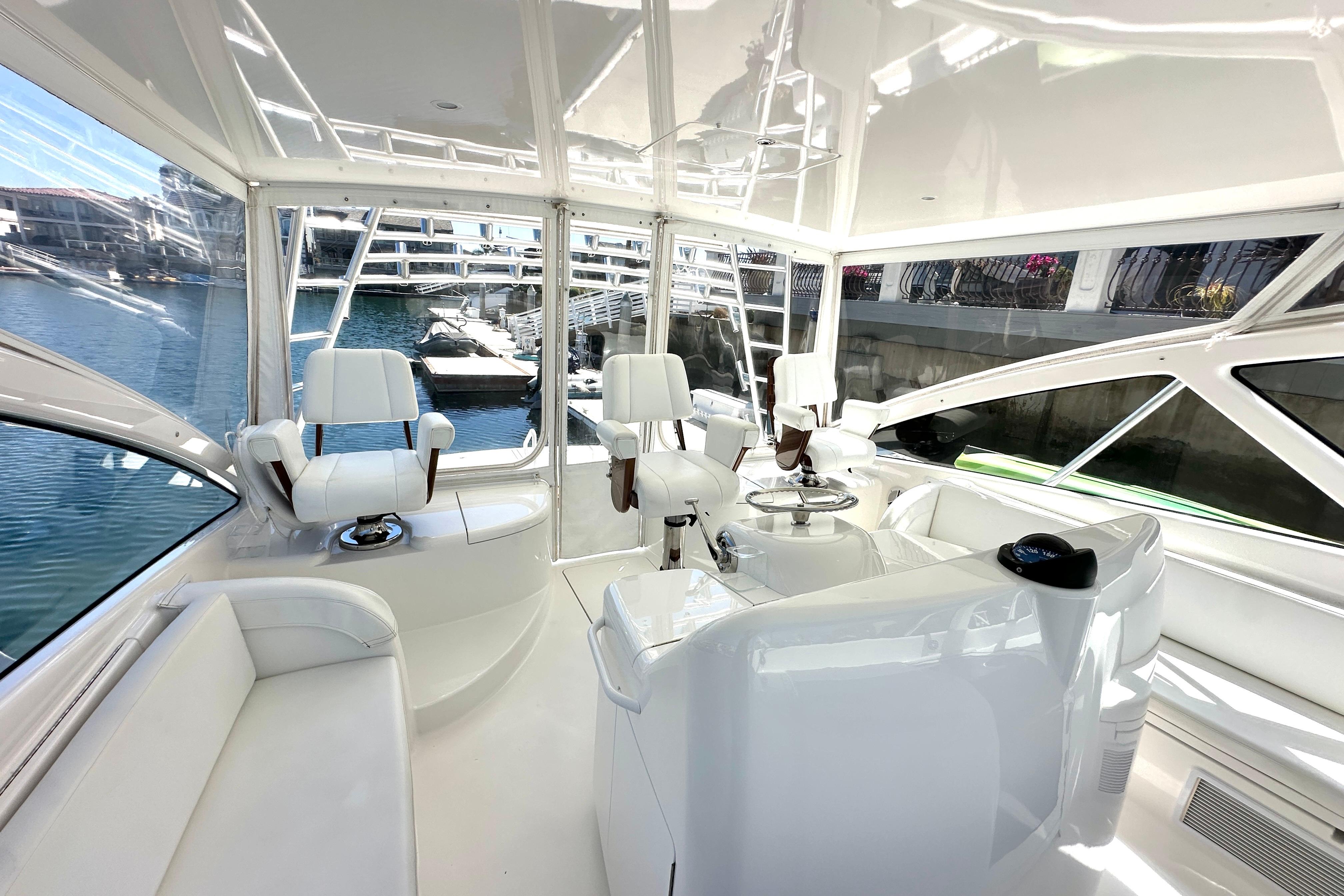 Luxurious interior of a 2012 Viking 42 Open yacht with white seating and helm.