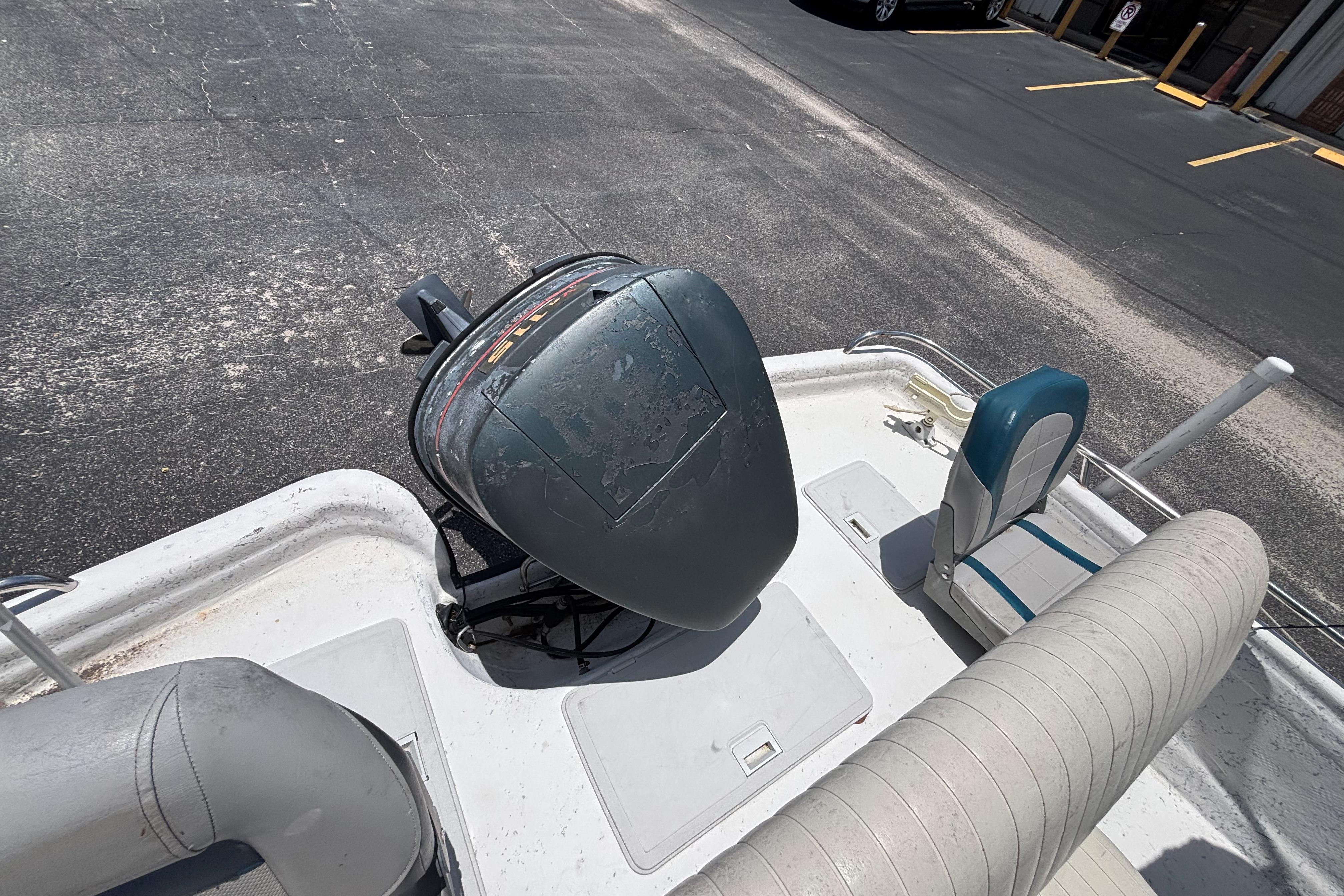 2000 VIP 1880 Bay Stealth boat with motor and seating, parked on asphalt.