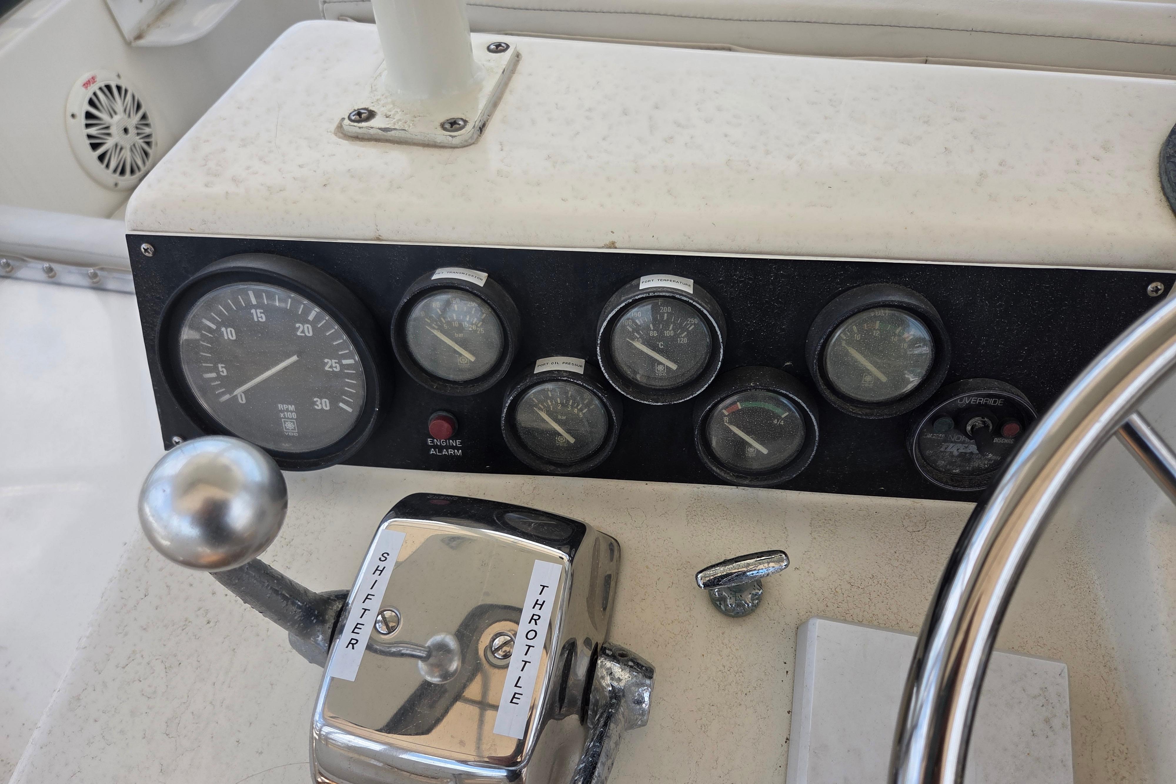 Control panel of a 1990 Egg Harbor Golden Egg 42 boat with gauges and throttle.