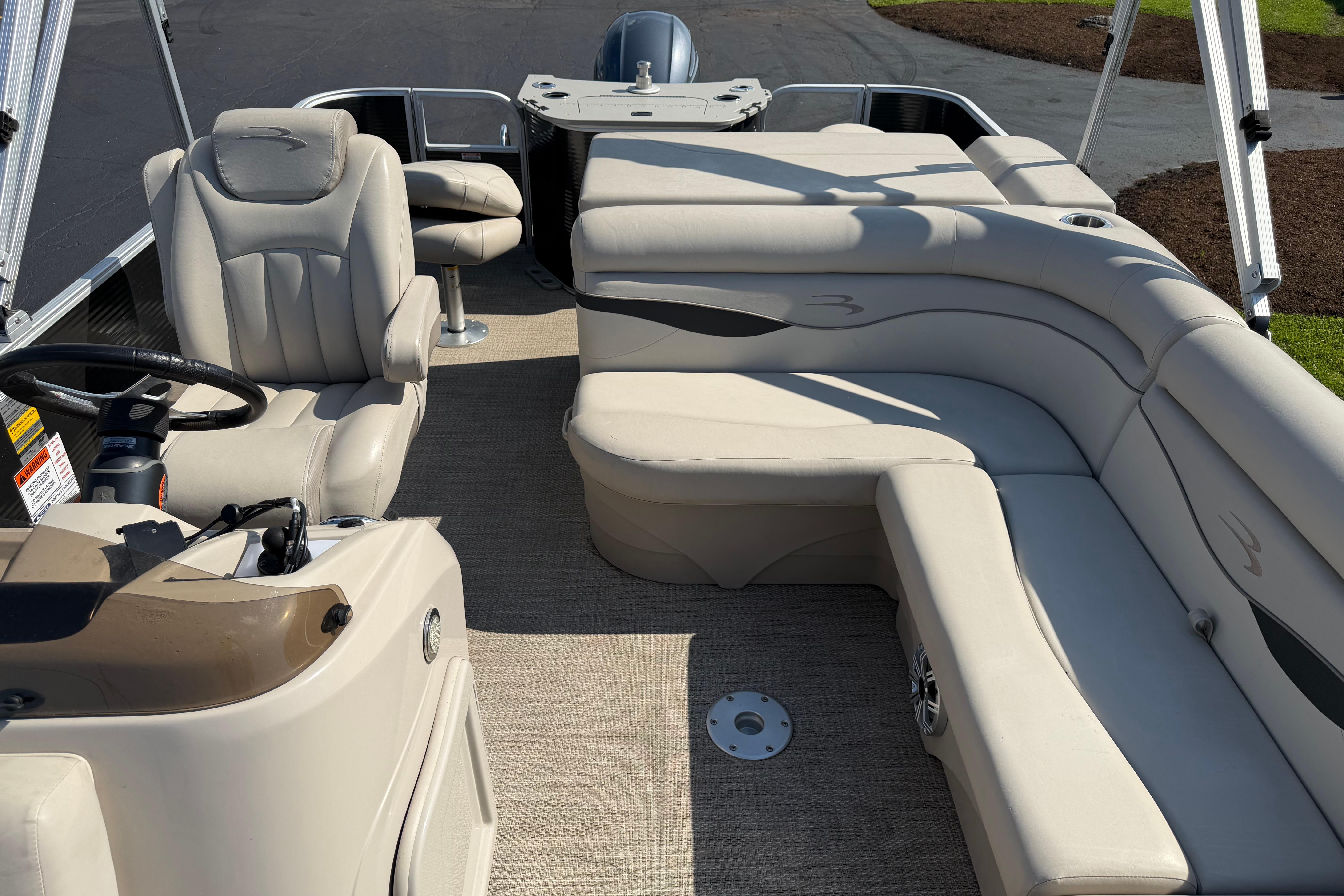 2018 Bennington 21 SF pontoon boat interior with beige seating and steering console.