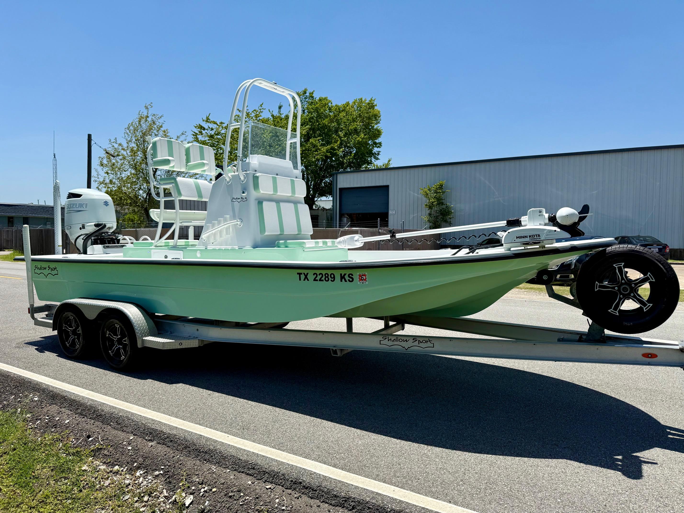 2023 Shallow Sport 24 Sport boat on trailer, mint green, parked on road.