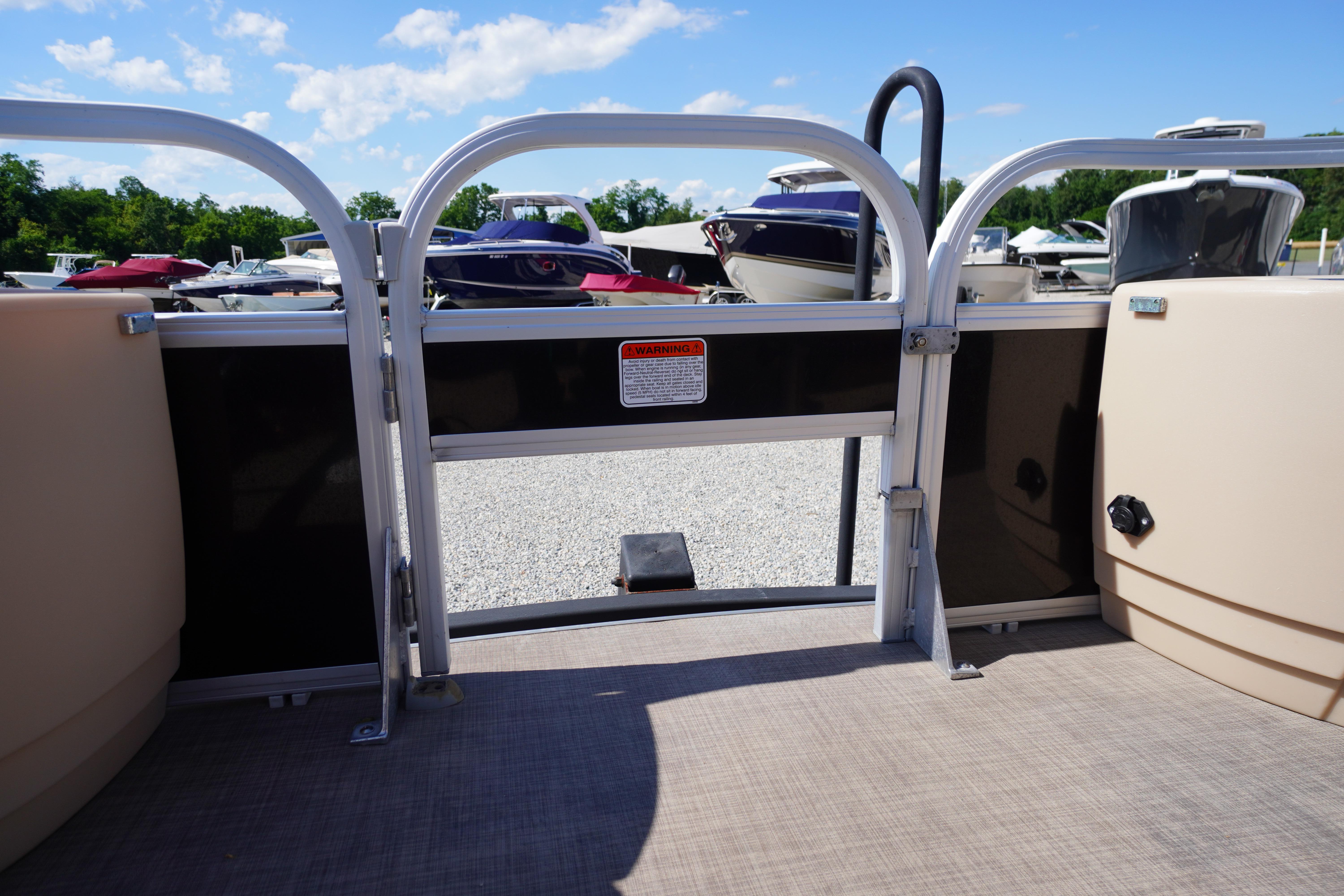 2019 SUNTRACKER Fishin' Barge 22 DLX deck view with open gate, boats in background.