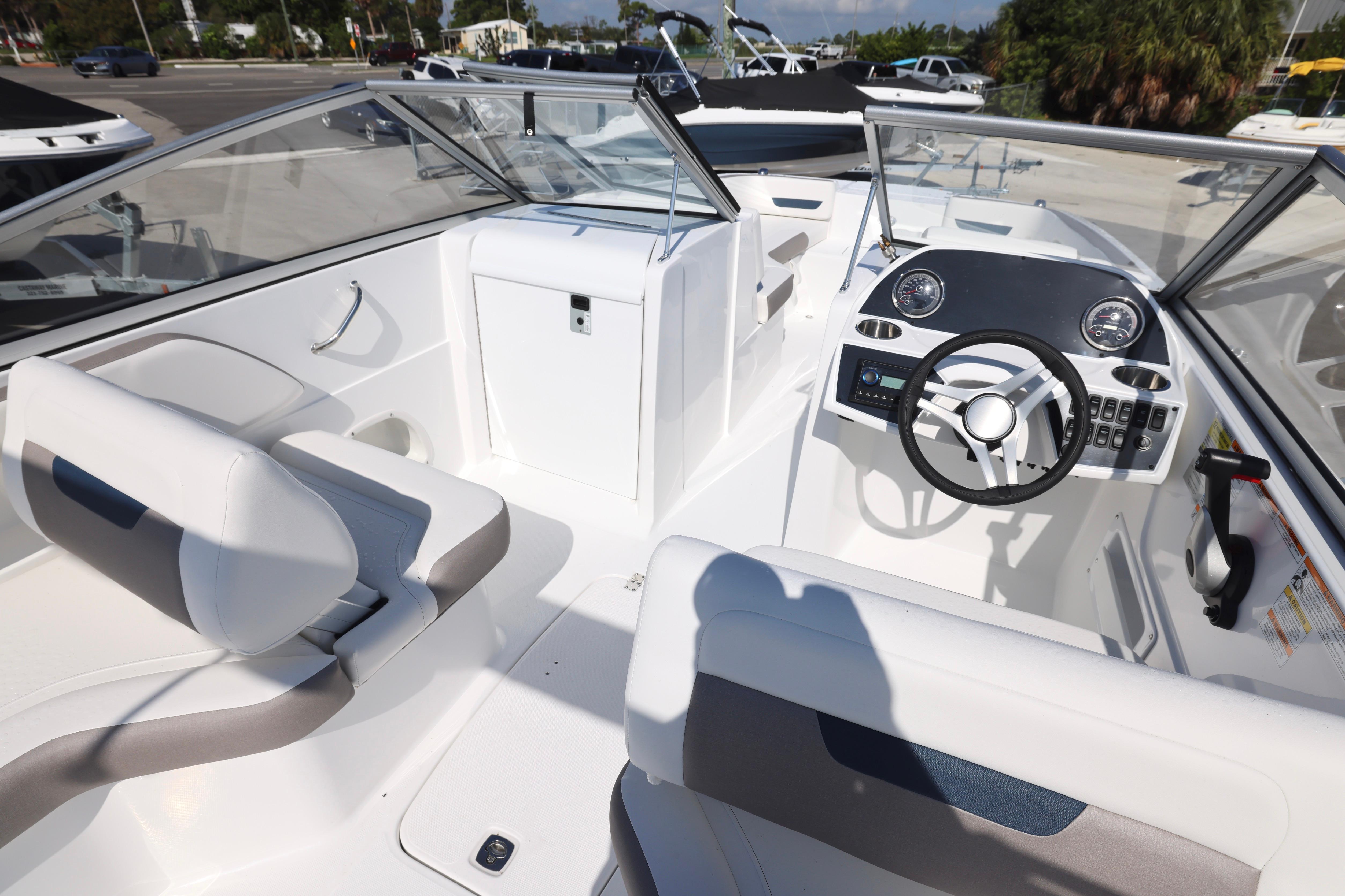 2026 Hurricane SunDeck 235 OB boat interior with steering wheel and seating.