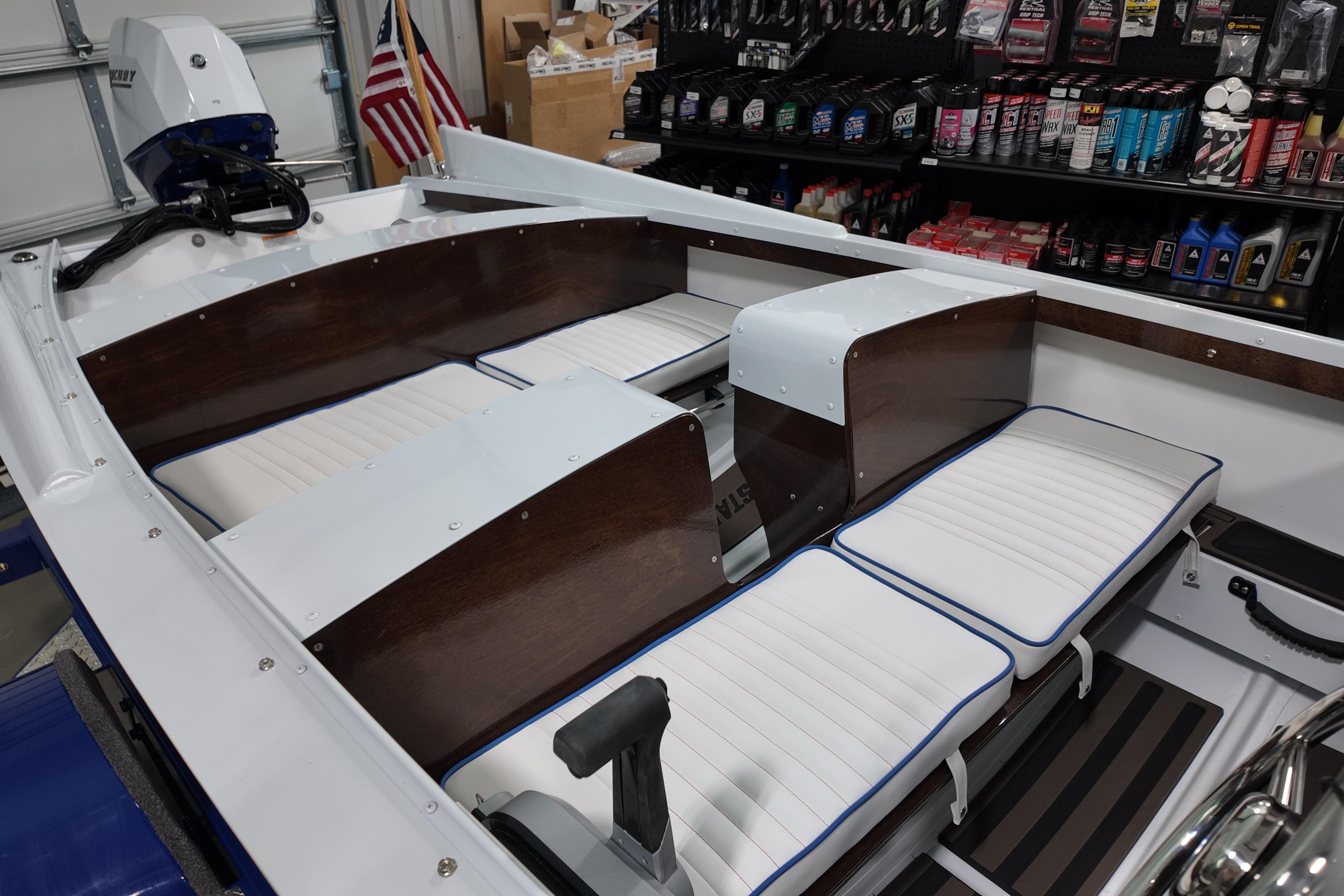 Interior of a 2026 Starcraft 57 Ski Champ boat with white and wood seating.