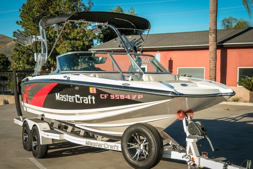 2013 MasterCraft X-2 boat on trailer, parked outdoors, with vibrant graphics and sleek design.