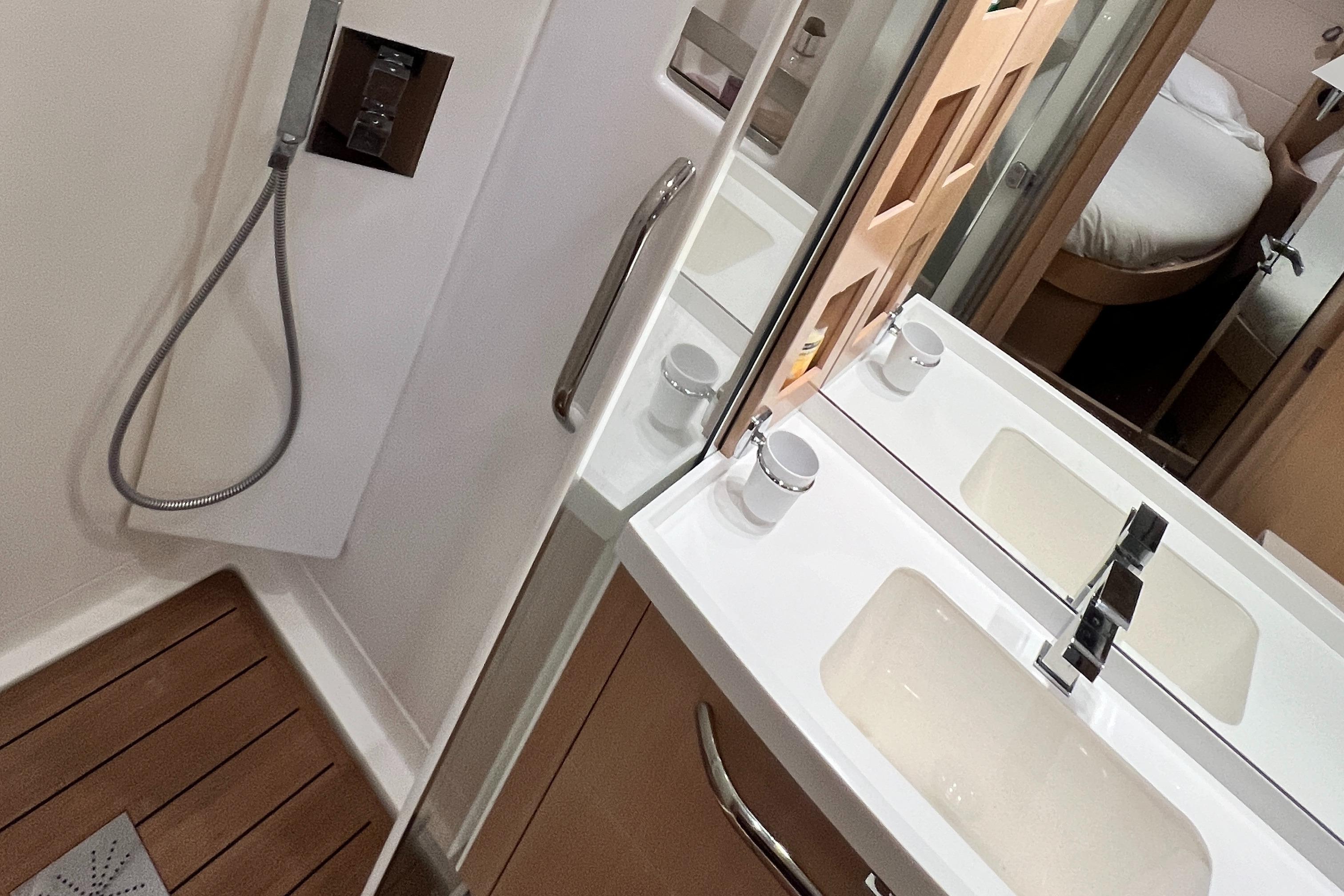Luxurious bathroom in 2016 Amel 64 yacht with modern fixtures and wooden flooring.