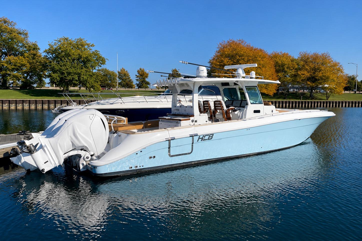 2022 HCB 42 Lujo boat docked on calm water with trees in the background.