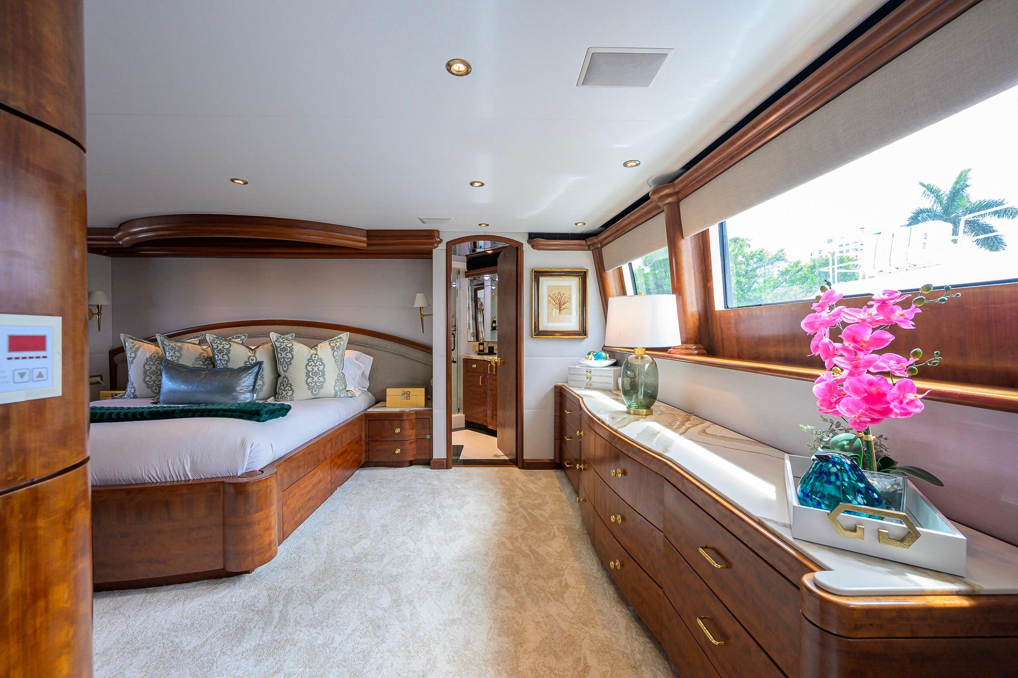 Luxurious bedroom interior on 2003 Cheoy Lee Trideck yacht with elegant wood finishes.