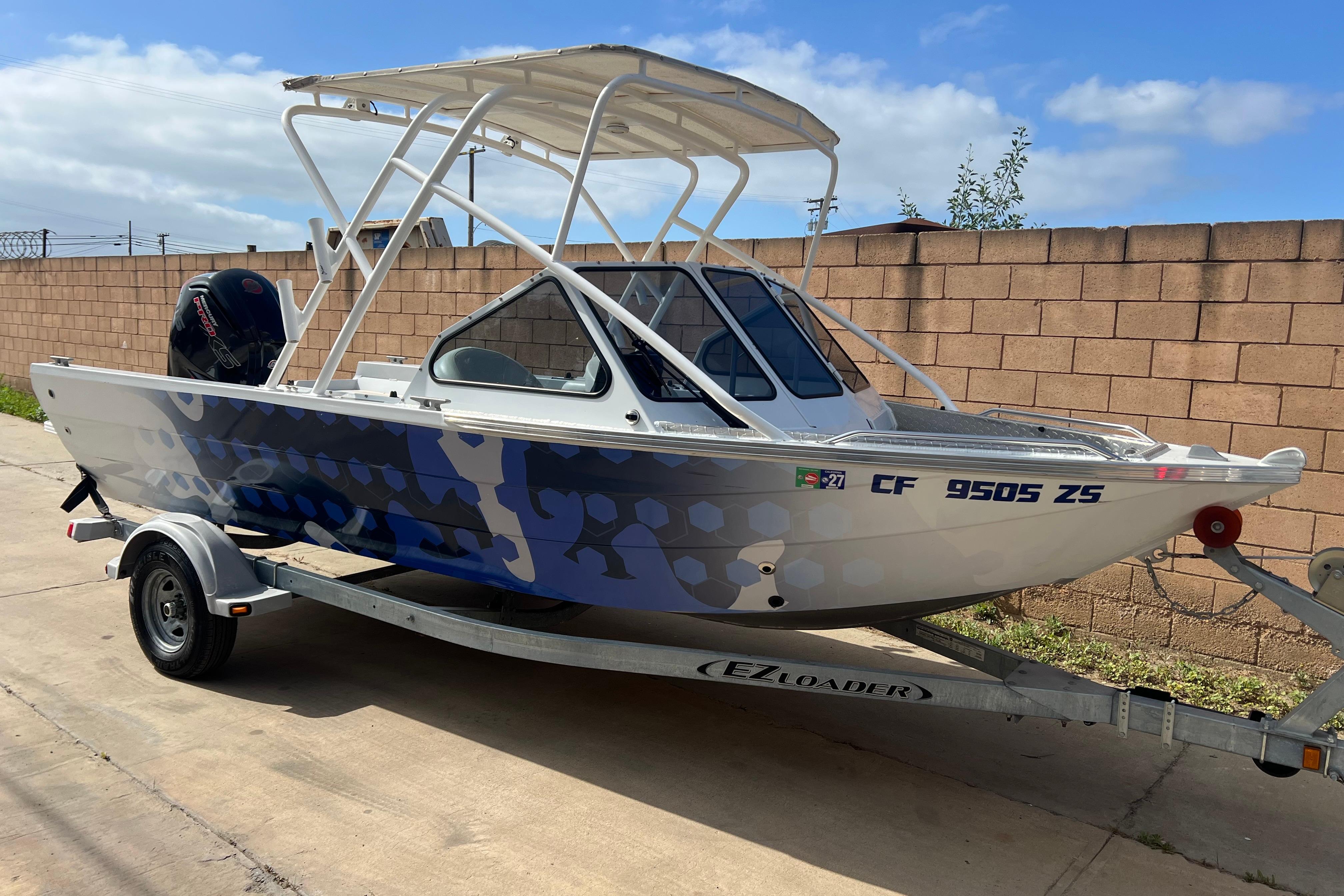 2019 KingFisher 1825 Falcon boat on trailer, parked outdoors, featuring a sleek design.