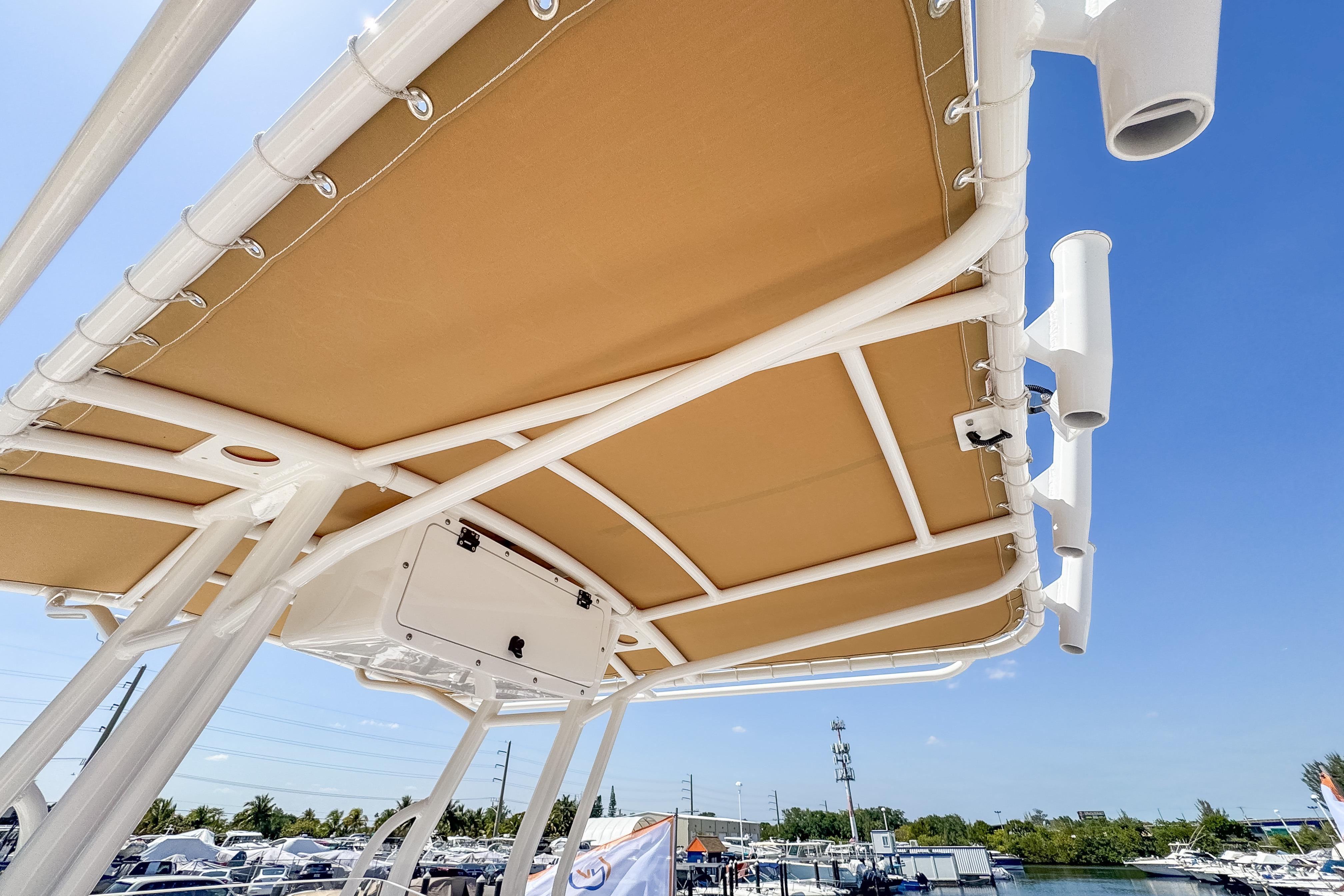 Edgewater 208CC 2025 boat canopy with rod holders, blue sky.