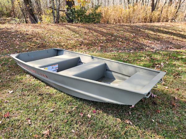 2025 Tracker Grizzly 1036 Utility boat on grassy area, surrounded by autumn trees.