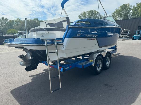 2018 Monterey 258 Super Sport boat on trailer, blue and white, parked outdoors.