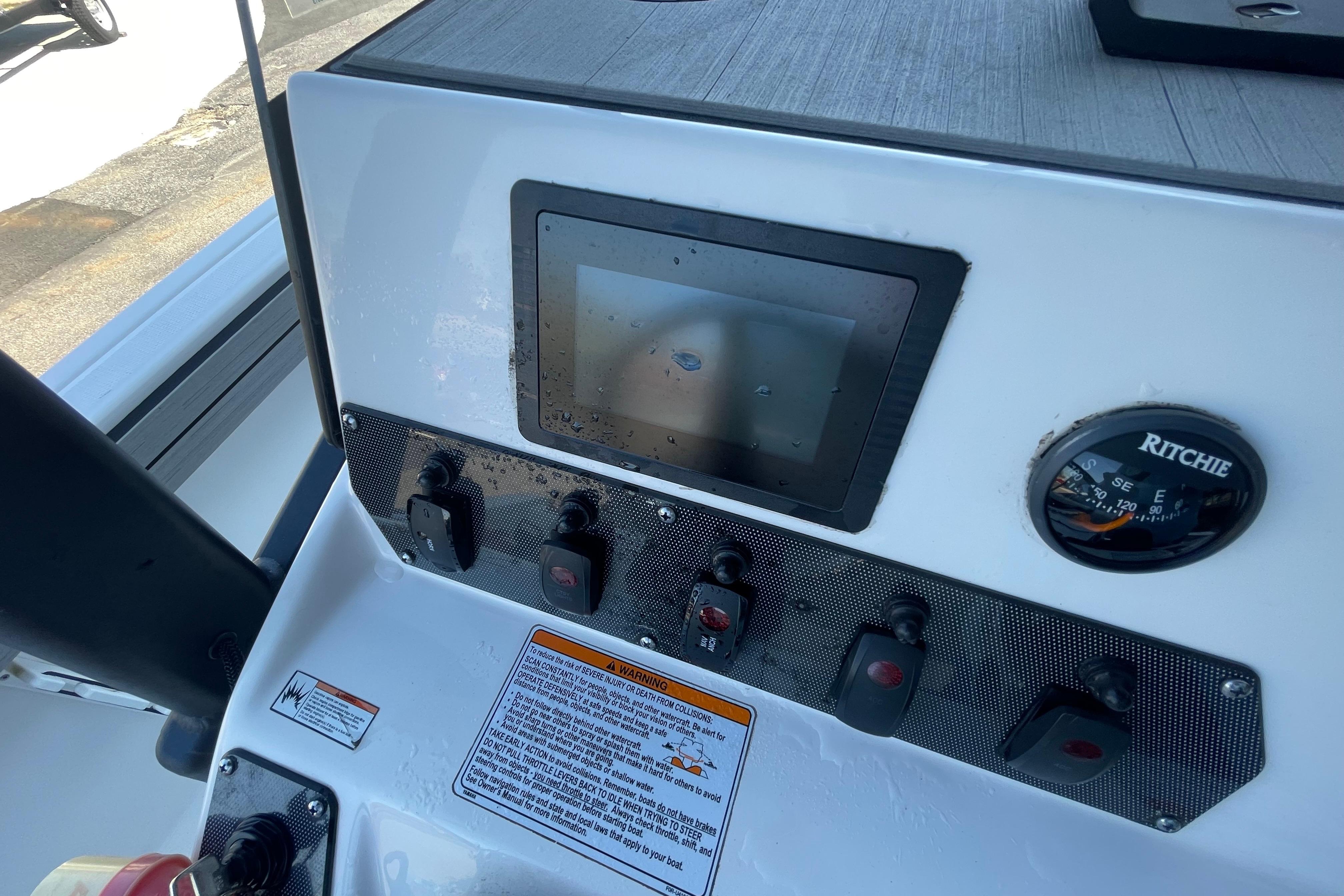 Control panel of 2021 Yamaha Boats 195 FSH Sport with touchscreen and compass.