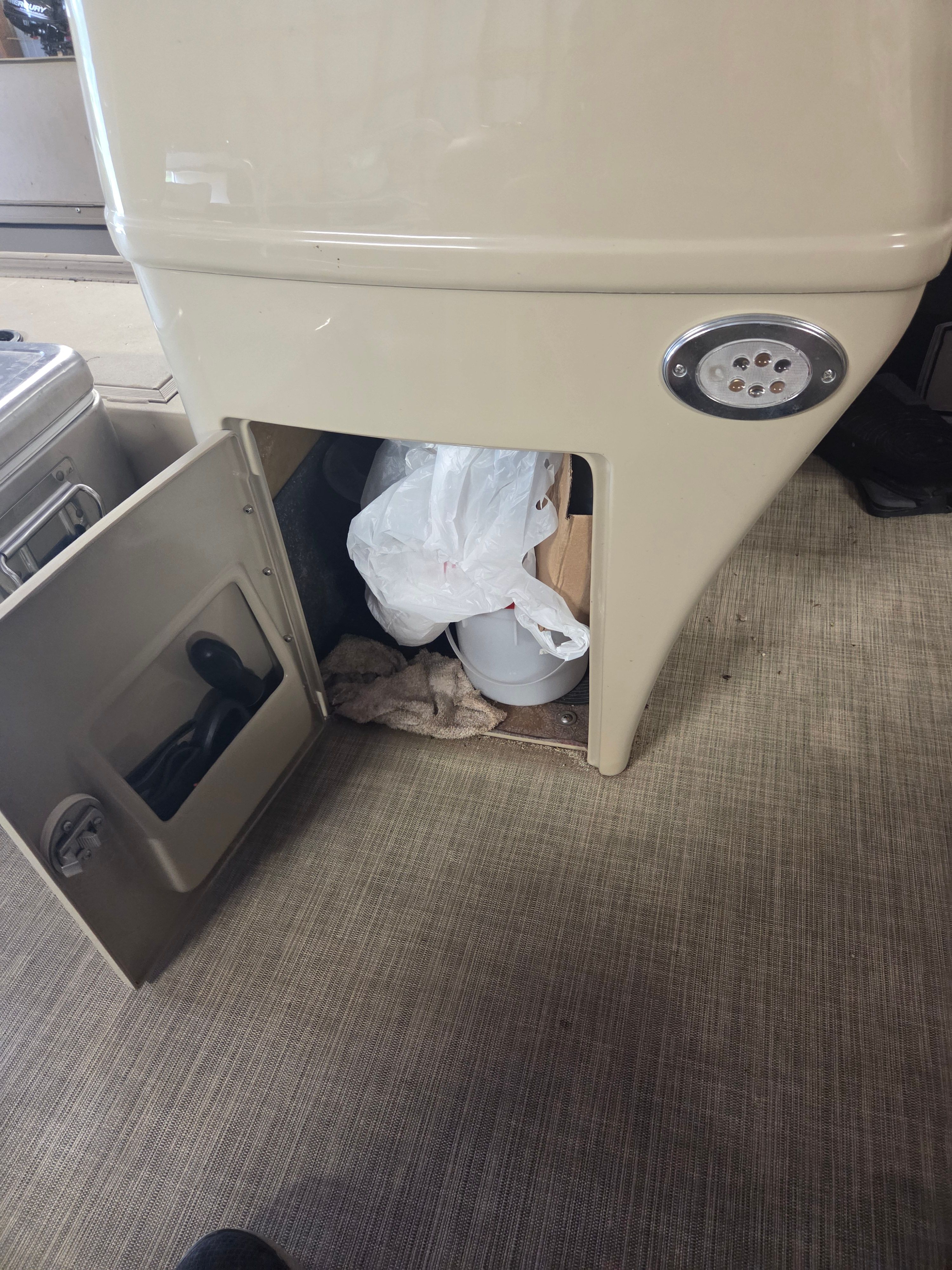An open storage compartment on a boat with various items inside.