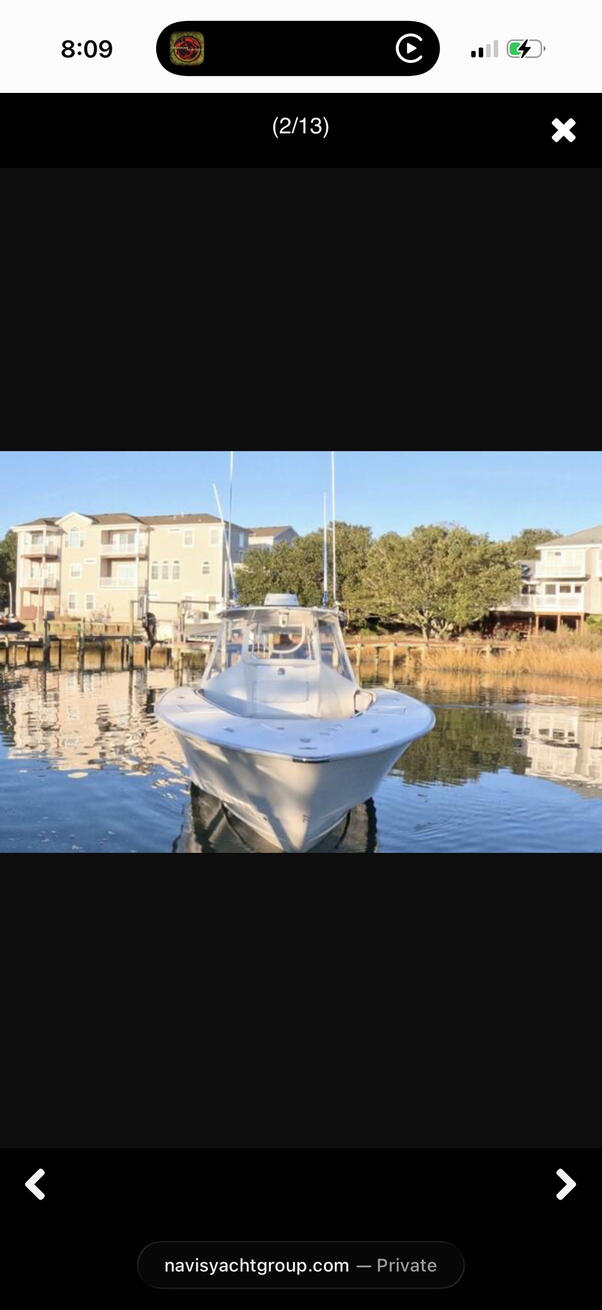 A 2007 Cape Horn 36T boat sits calmly on the water near docks and houses.