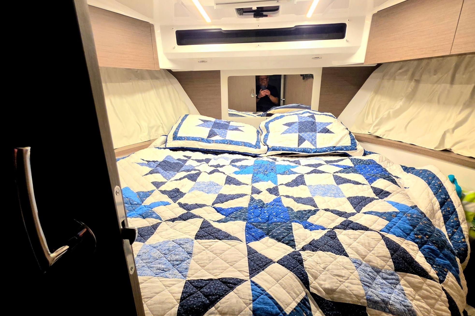 Cozy bedroom in 2026 Jeanneau NC 895 Series 2 with blue quilted bedding.