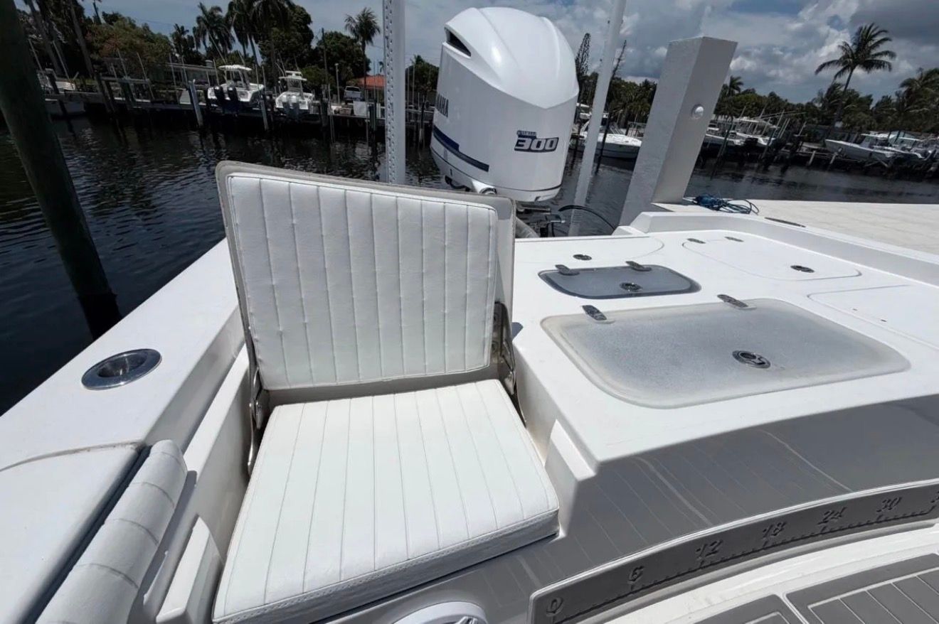 A 2016 Contender 25 Bay with a white seat and a Yamaha outboard motor.