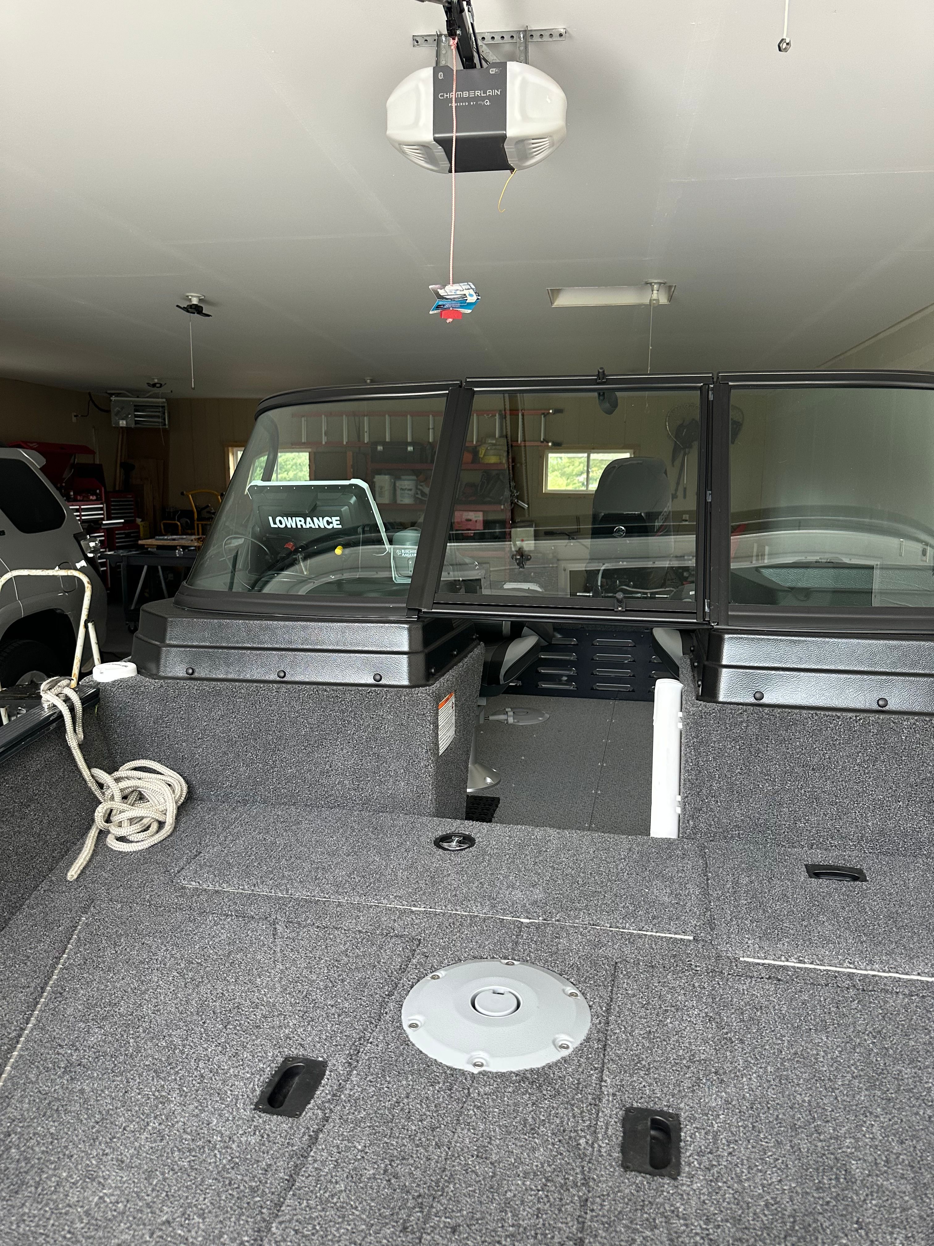 The image shows the interior of a Lund Pro Angler 1650 boat in a garage.