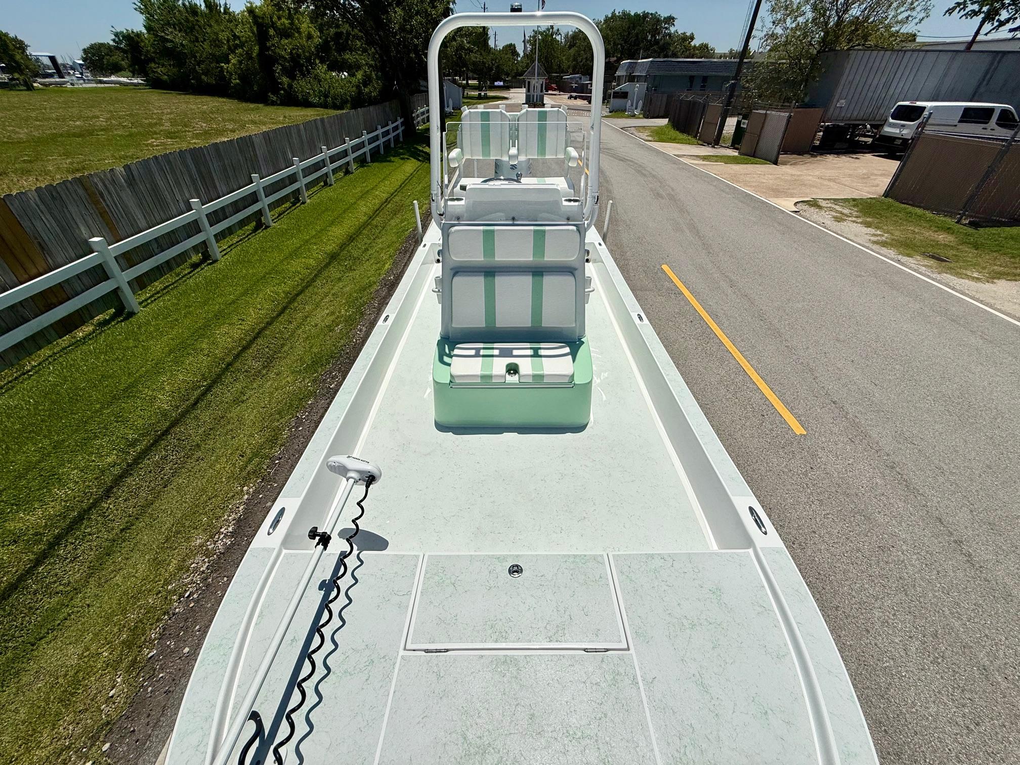 2023 Shallow Sport 24 Sport boat on road, showcasing deck and seating.