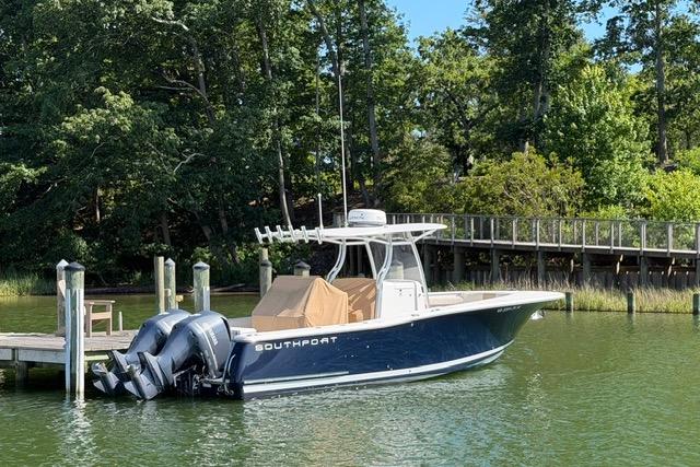 2014 Southport 29 FE boat docked on a serene lake with lush greenery.