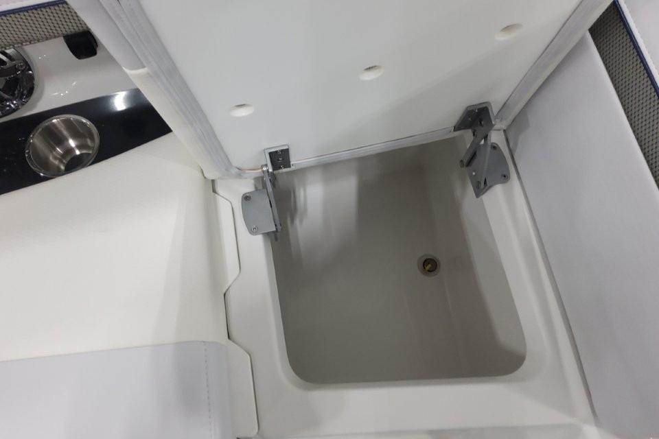Open storage compartment on 2026 Formula 310 Bowrider boat, featuring stainless steel fixtures.