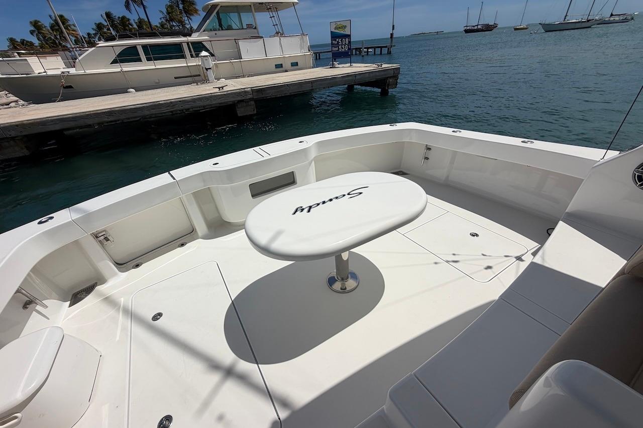 Viking 50 Convertible 2012 yacht deck with table, docked by the sea.