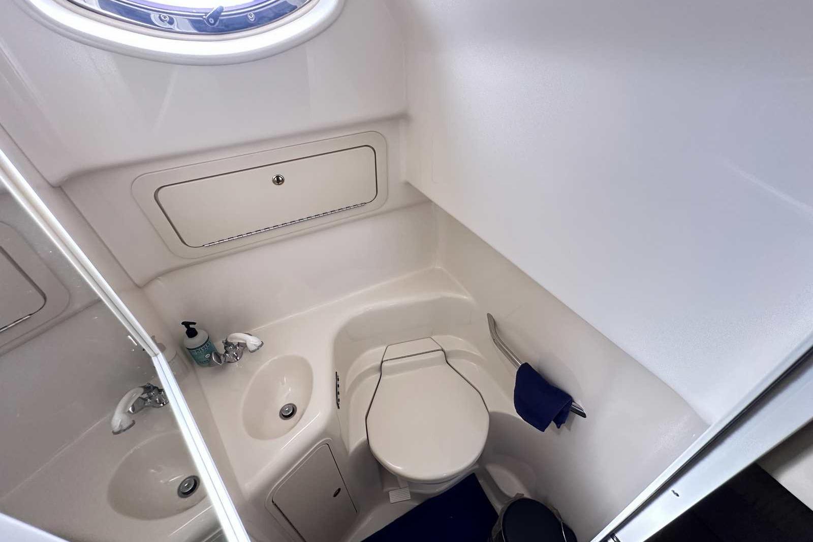 Bathroom interior of 2000 Sea Ray 410 Sundancer yacht, featuring sink and toilet.